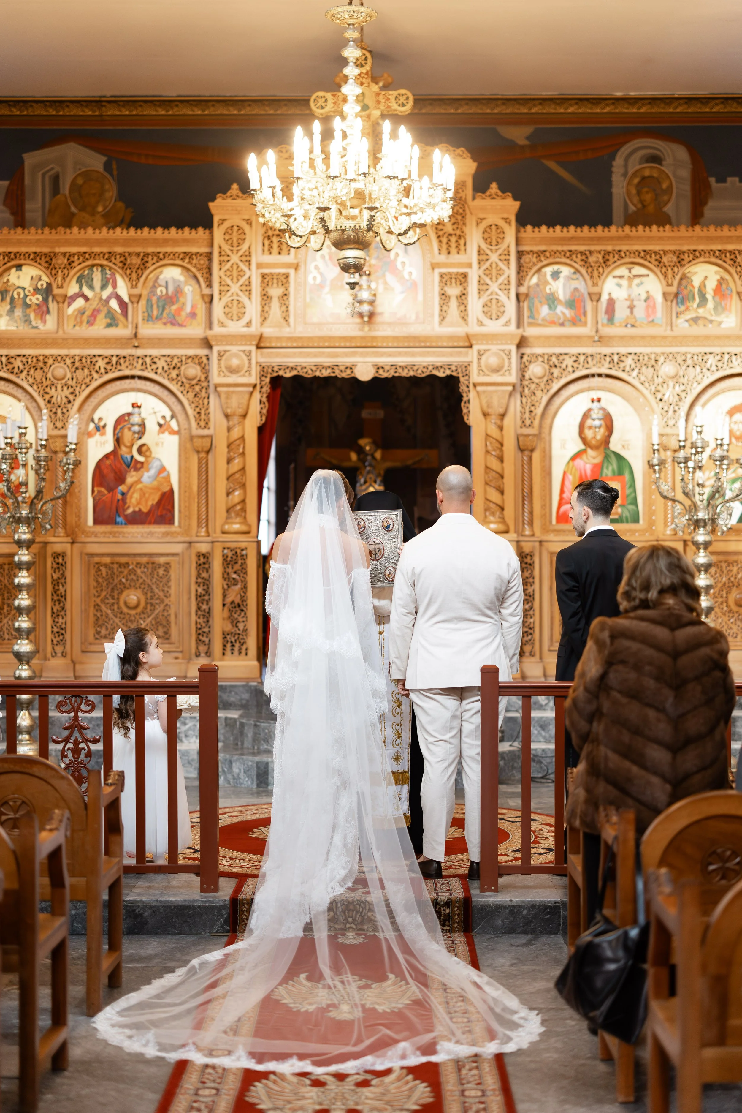 Steph and Alex stand before the iconostasis at Holy Monastery of Panagia Kamariani, seen from behind