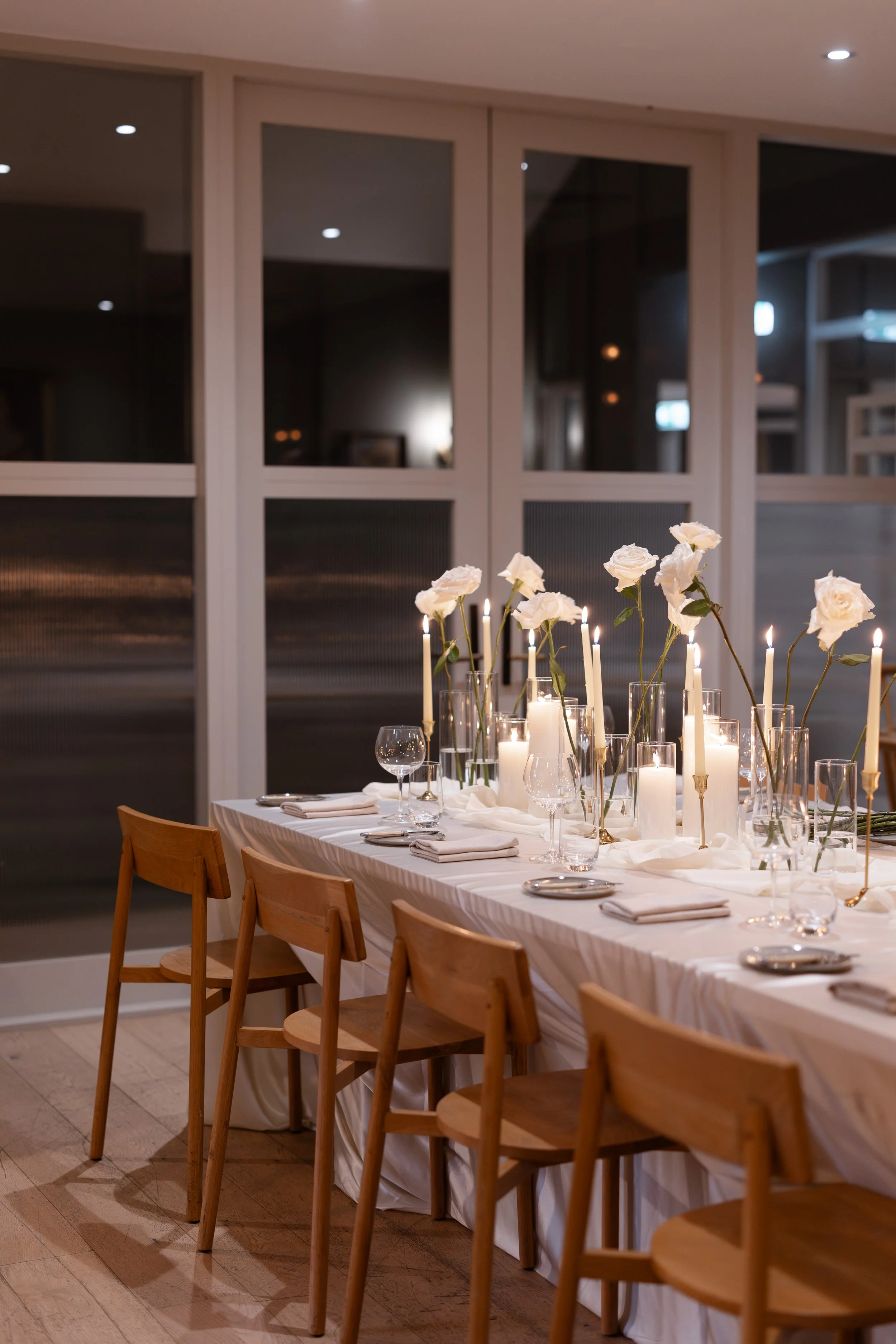 Steph and Alex's reception table with candles and white florals at Lindenderry Red Hill