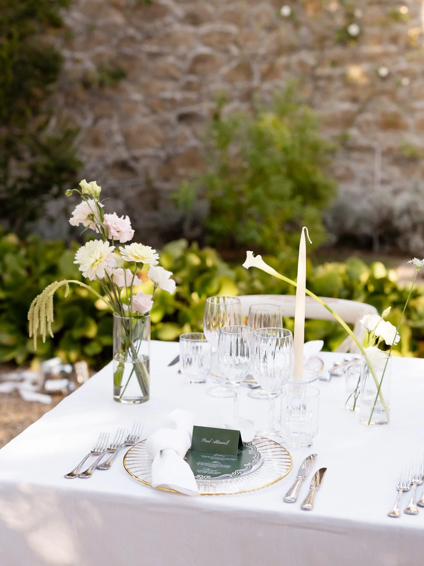 Reception table styled with white flowers, candles and greenery