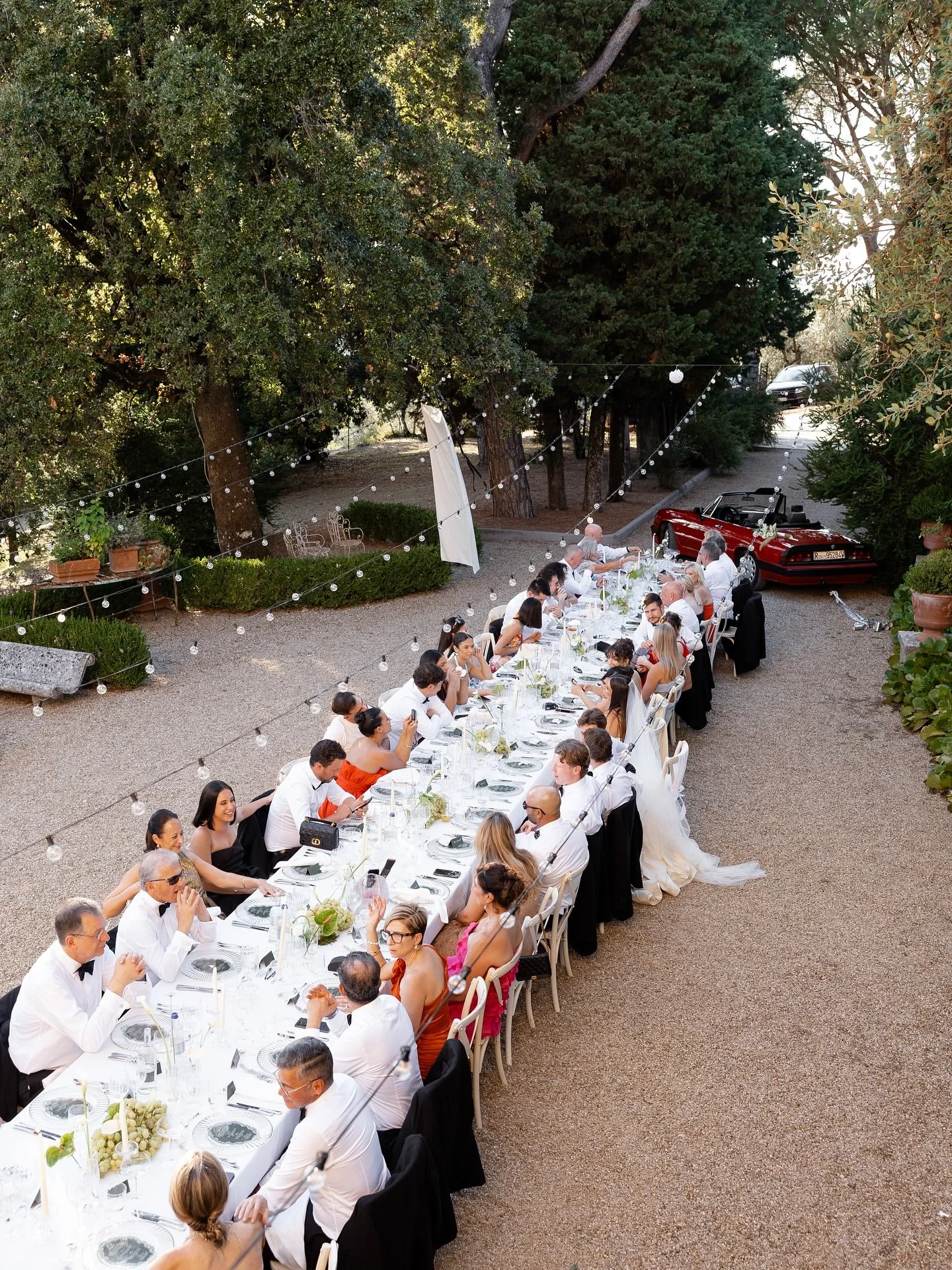 Long banquet table filled with guests enjoying the wedding dinner