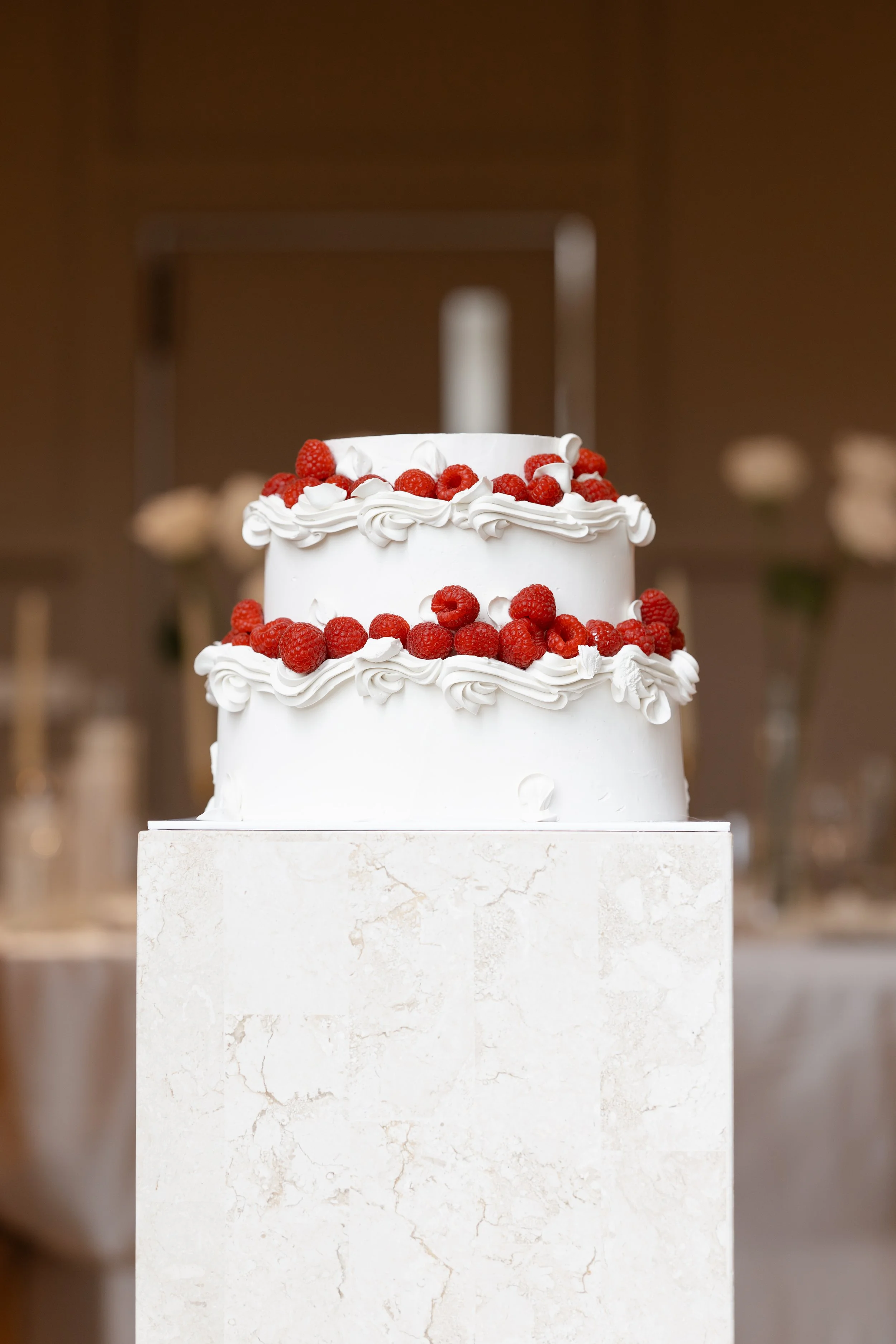 Steph and Alex's white wedding cake topped with red berries