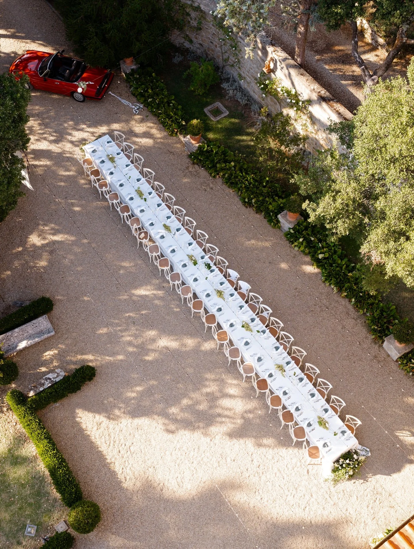 Aerial view of the long wedding dinner table on the gravel terrace at Villa Belvedere, Tuscany