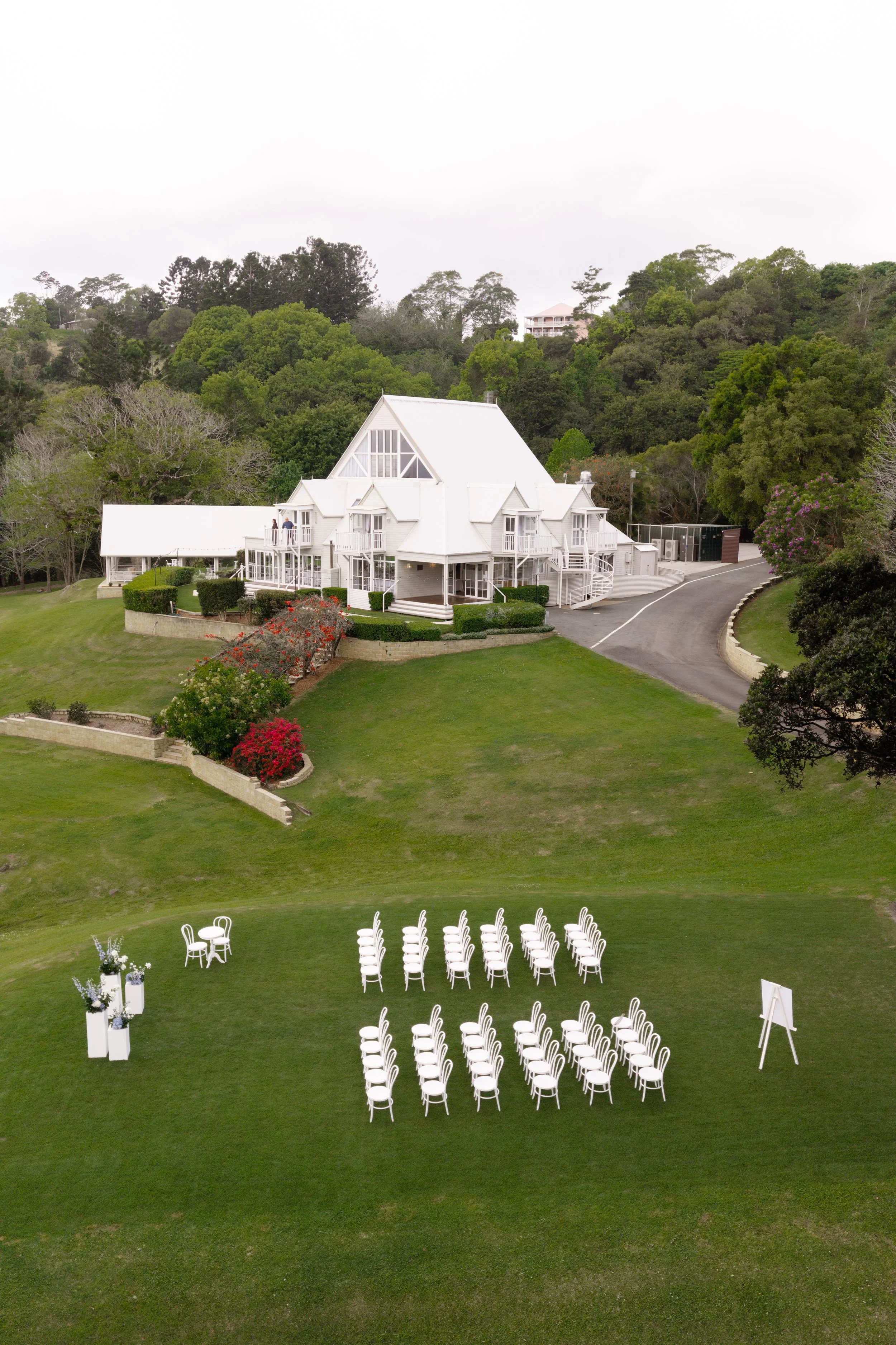 Aerial view of the ceremony lawn at Maleny Manor with white chairs set out below the manor house