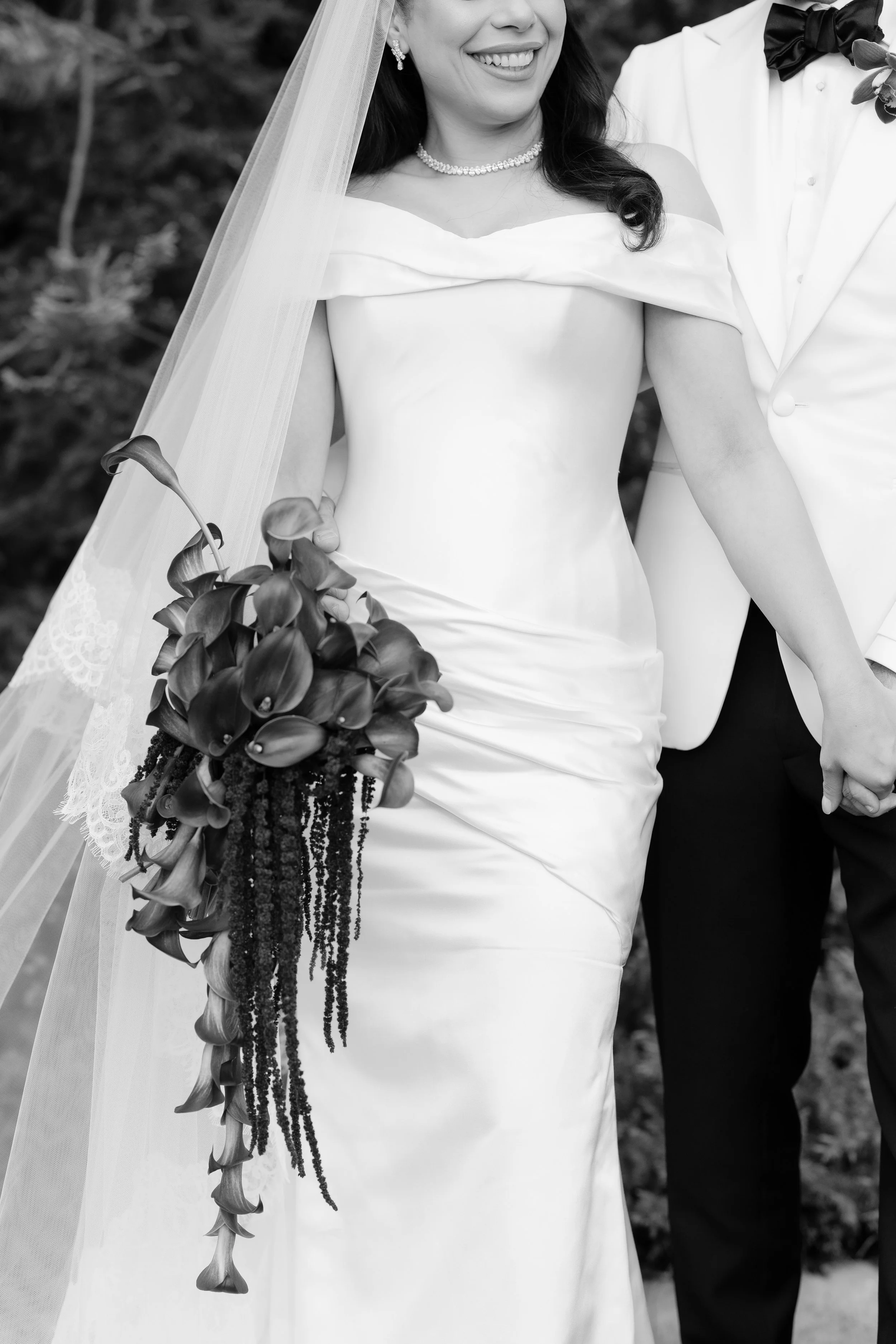 Jihan holding a trailing burgundy bouquet in a black-and-white portrait