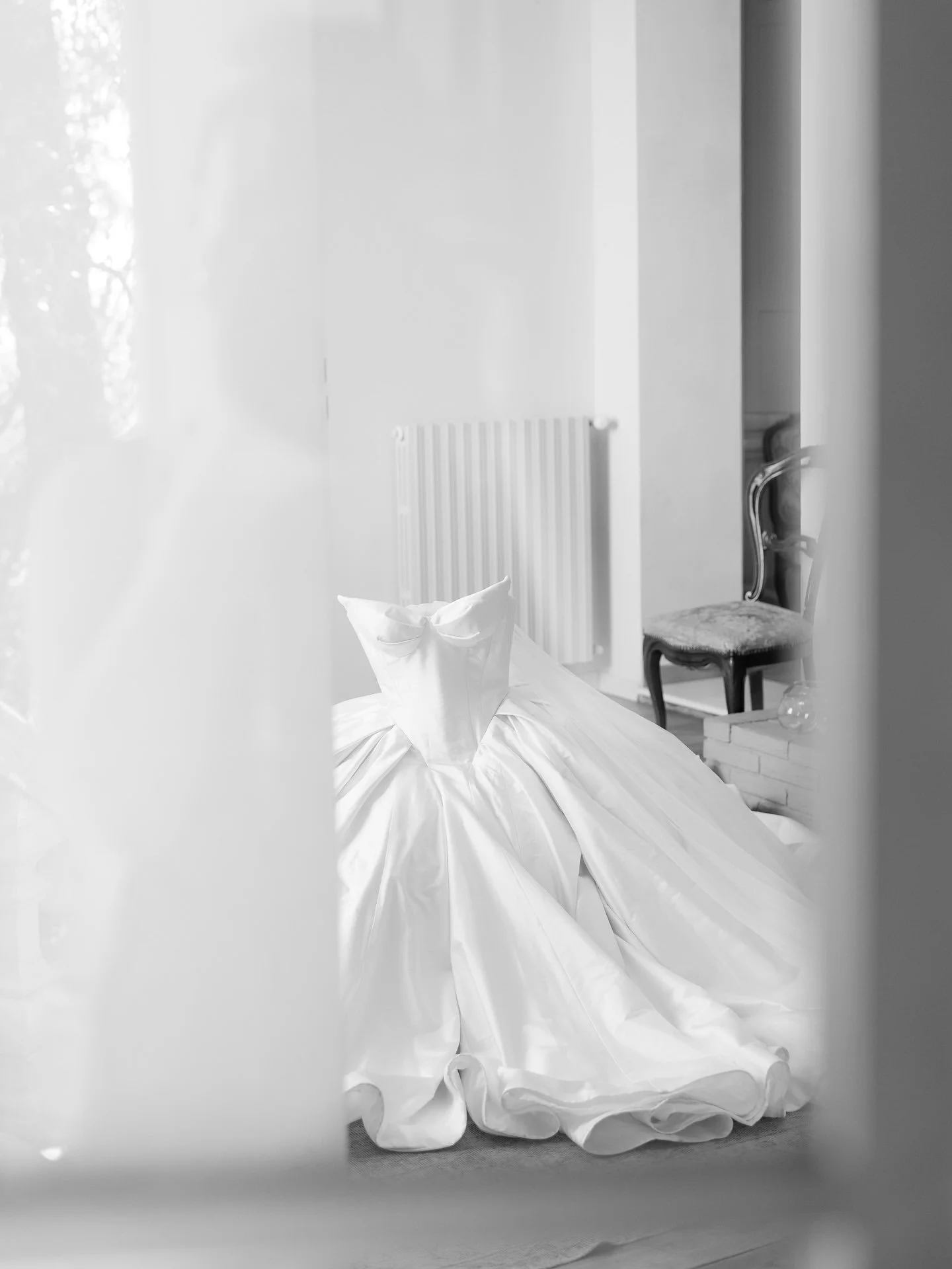 Black and white detail of the Leah Da Gloria wedding gown skirt beside a window at Villa Belvedere