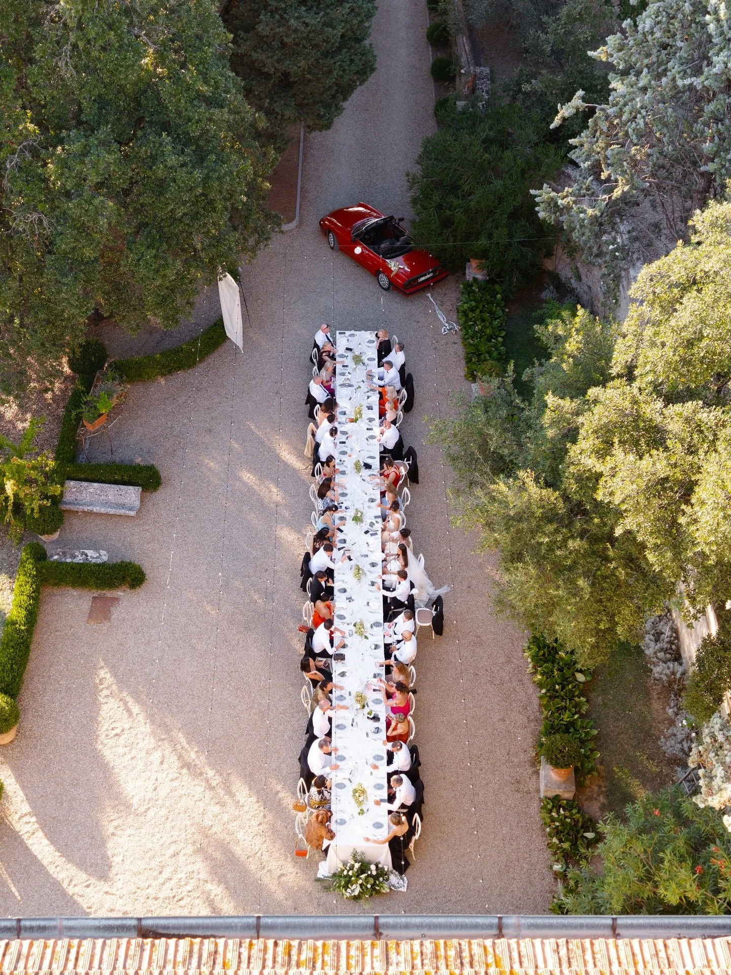 Long outdoor wedding dinner table set among the villa grounds in Tuscany