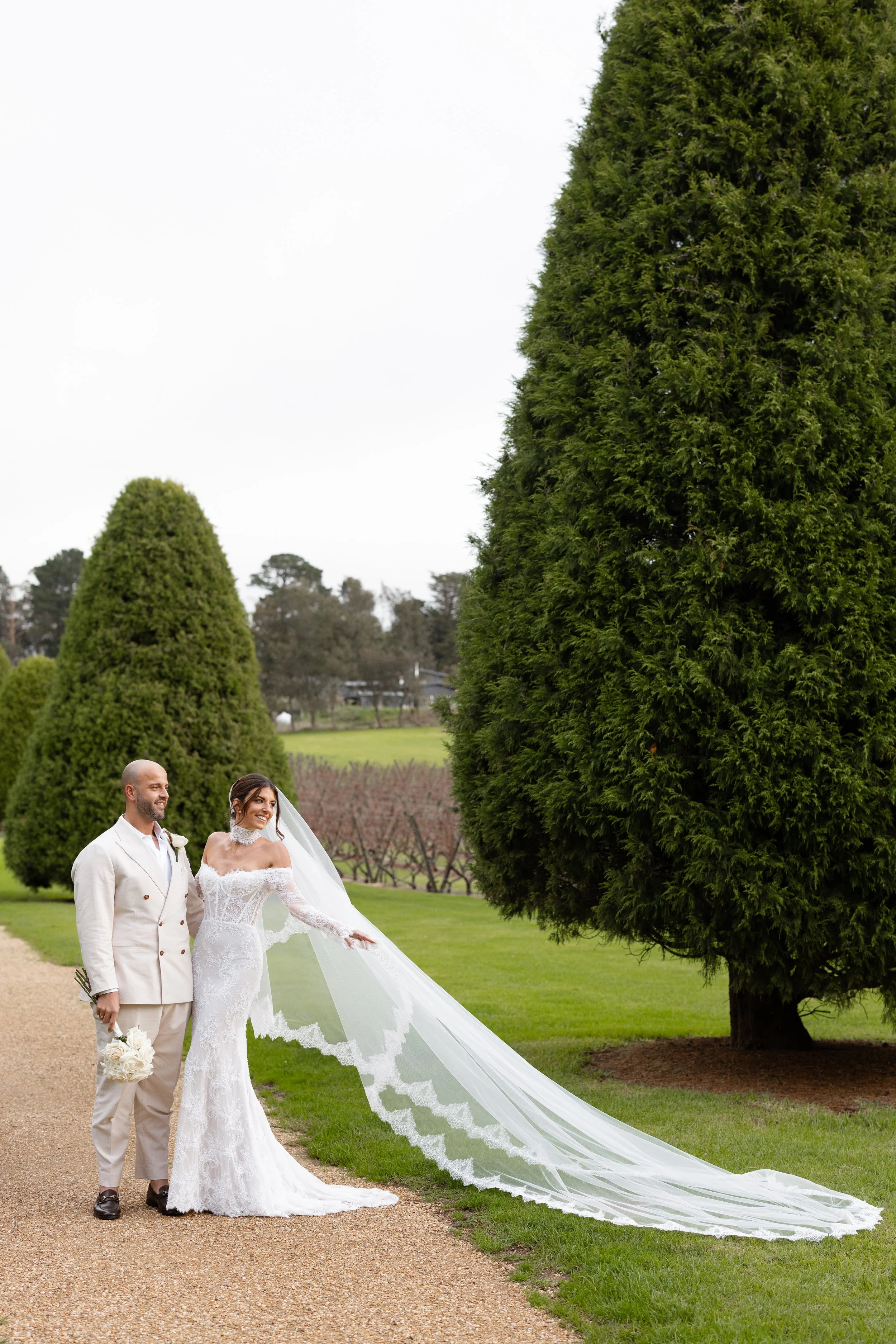 Steph and Alex among tall sculpted hedges in the gardens of Lindenderry Red Hill