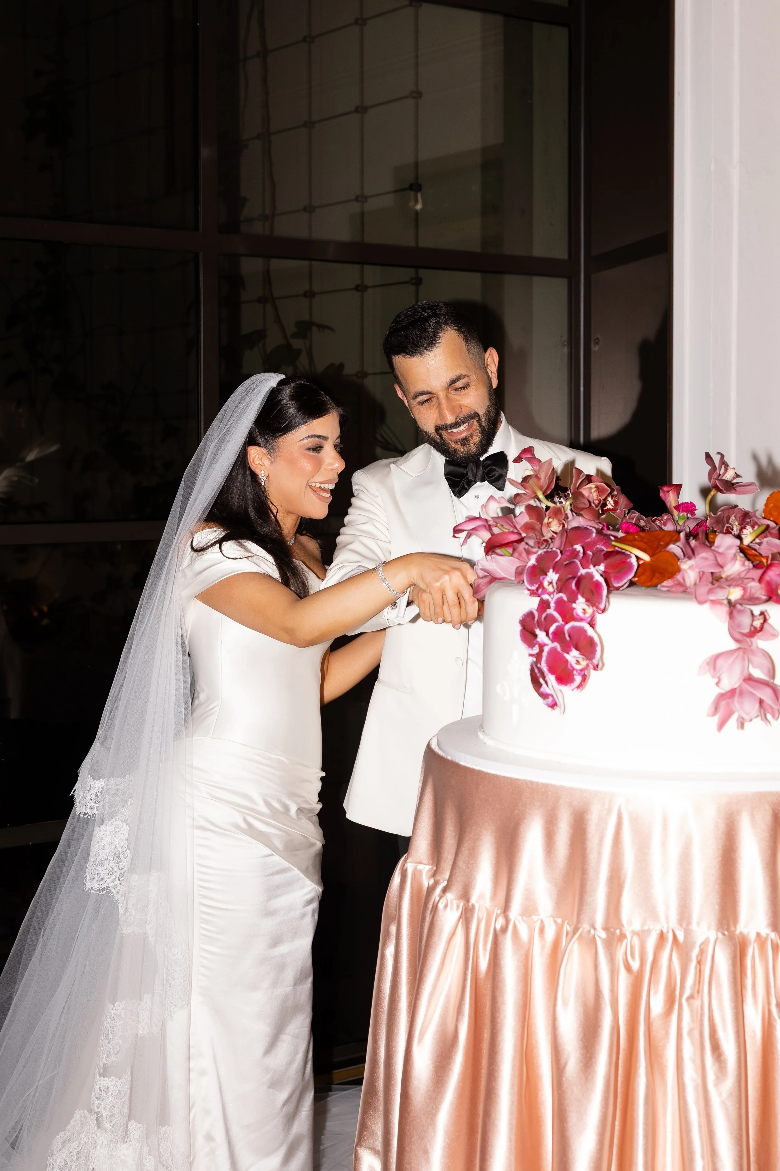 Jihan and Rob cutting their orchid-topped cake at Luci Melbourne