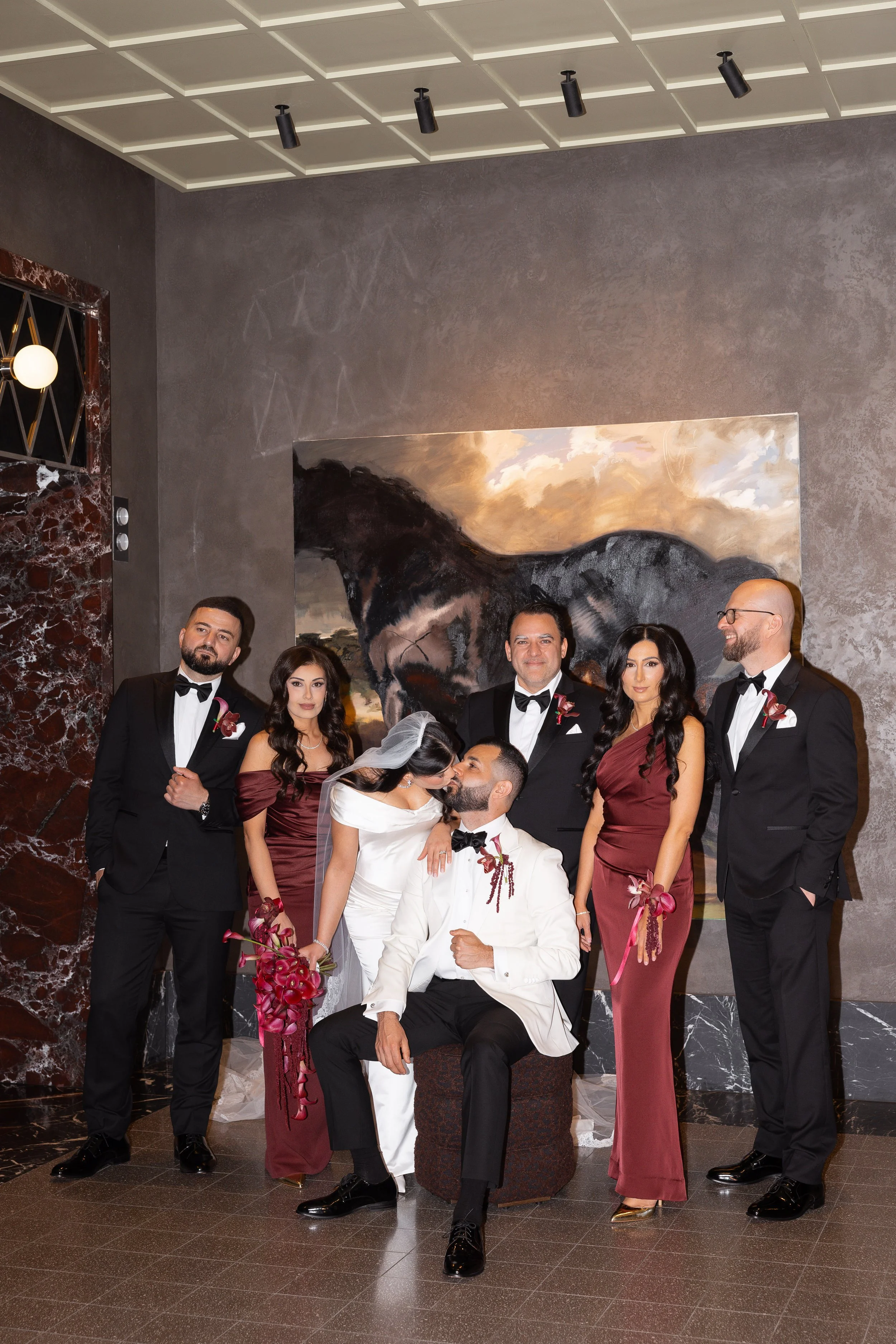Jihan and Rob with their wedding party by the hotel fireplace