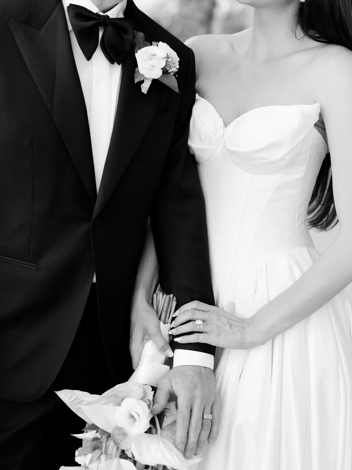 Black and white photo of the groom in his Oscar Hunt suit holding bride Marilena close