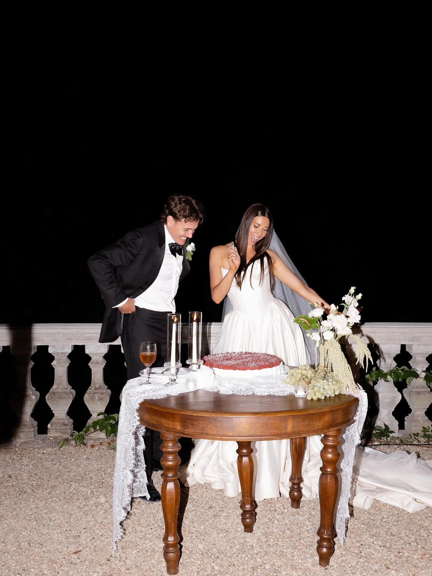 Marilena and Joshua at their wedding cake table on the terrace at night, Villa Belvedere, Tuscany