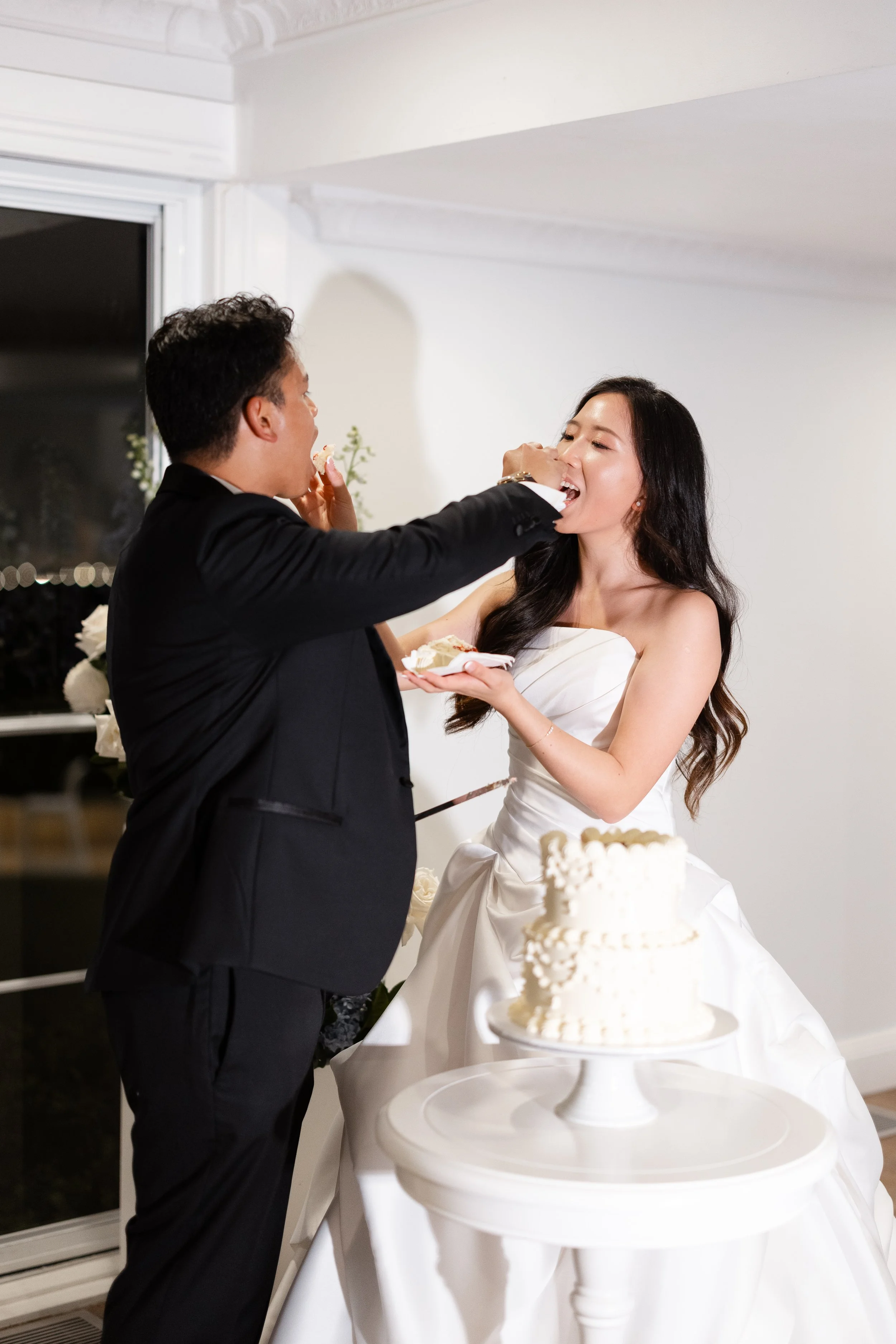 Alicia and Ezra at their cake cutting, Ezra feeding Alicia a bite of cake