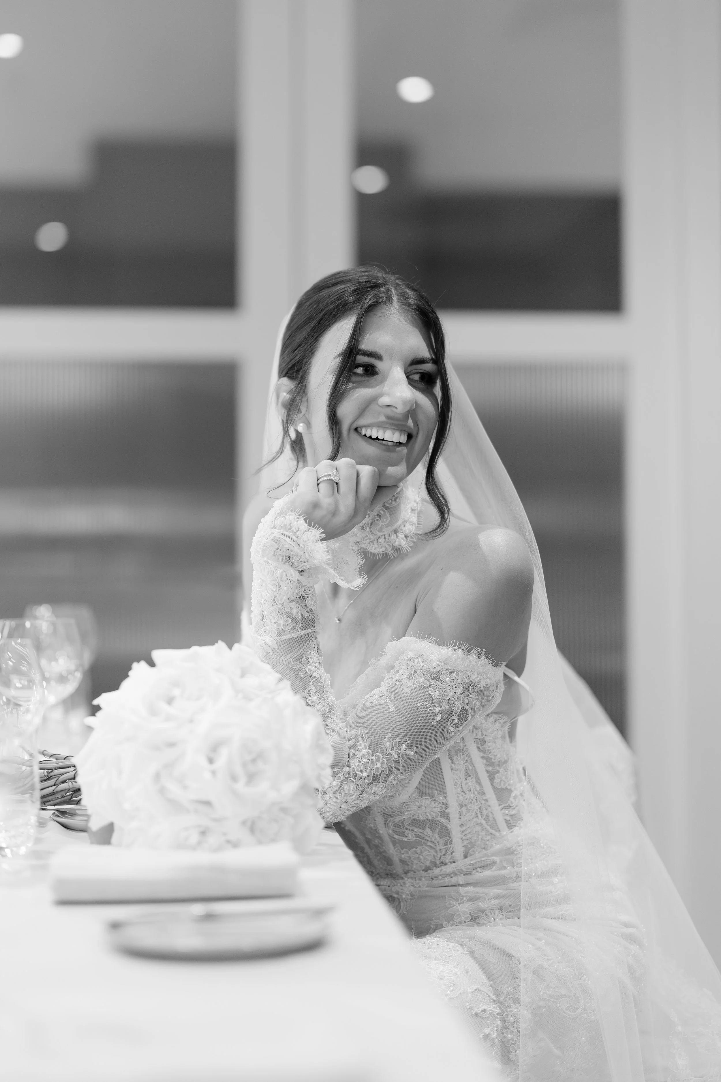 Steph smiling with a white bouquet in black and white