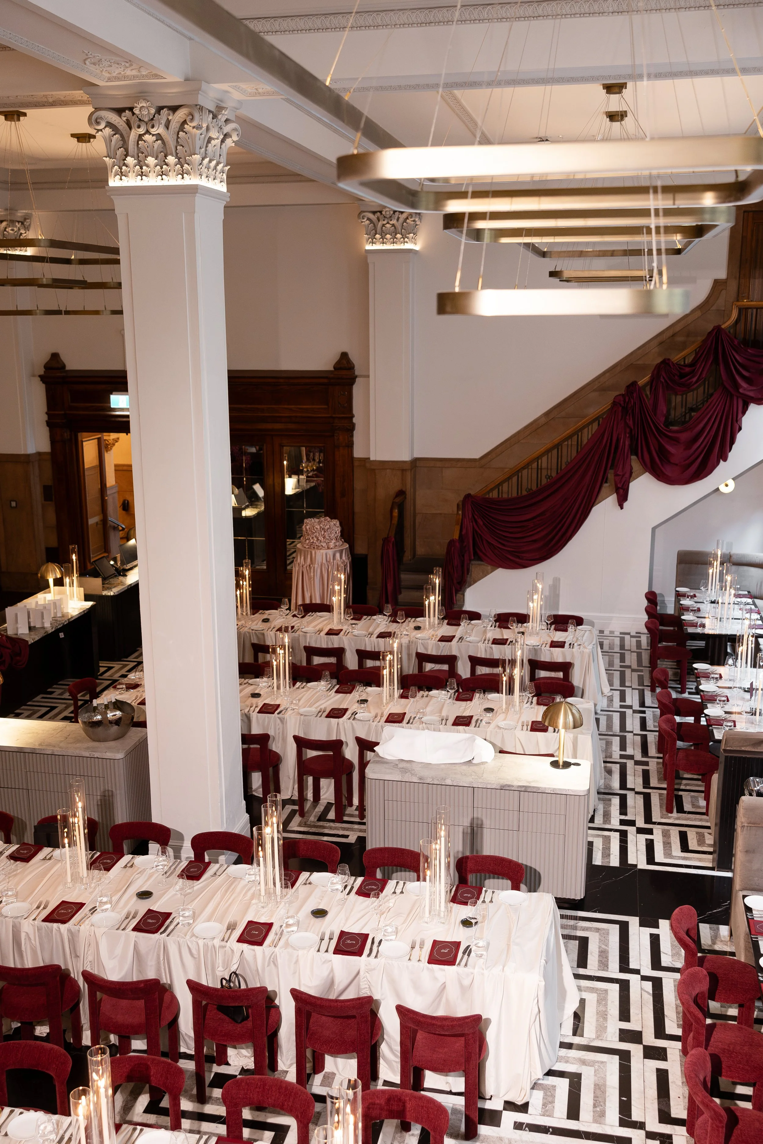 Jihan and Rob’s reception tables under burgundy drapes at Luci Melbourne
