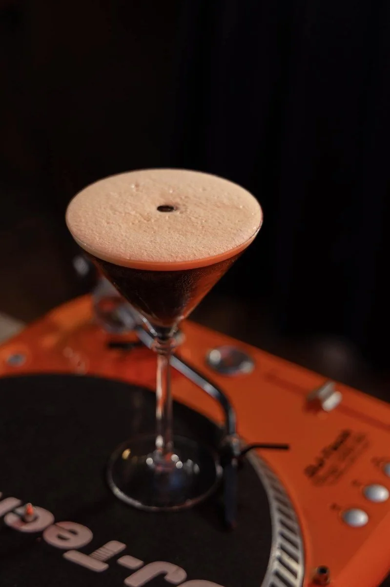 Espresso Martini sobre un tocadiscos naranja, en Standard Soho, Málaga