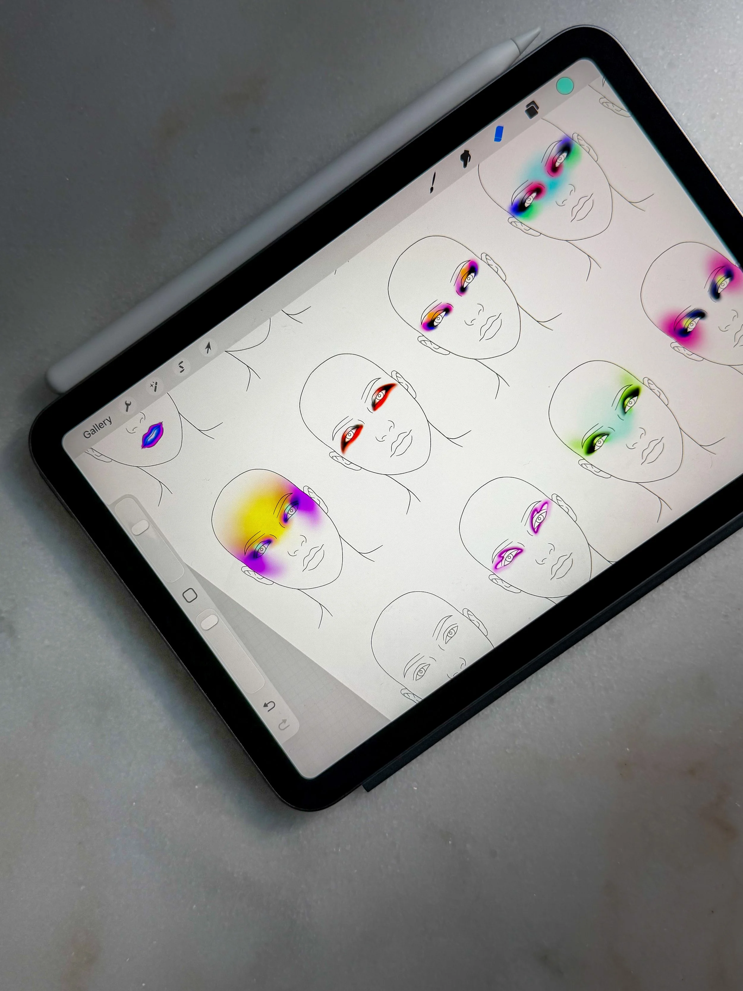 A tablet displaying a drawing app with sketches of human faces. Several faces have colorful heatmap overlays around the eyes and cheeks, indicating possible eye-tracking or focus points.
