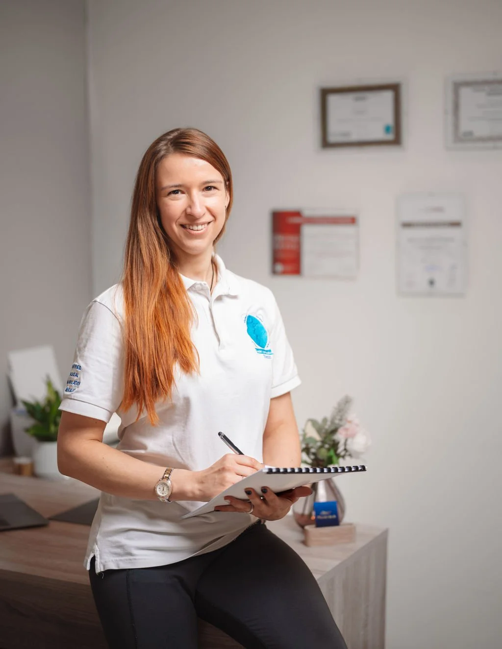 Physiotherapist wearing official Fascial Manipulation Stecco polo taking patient history during consultation