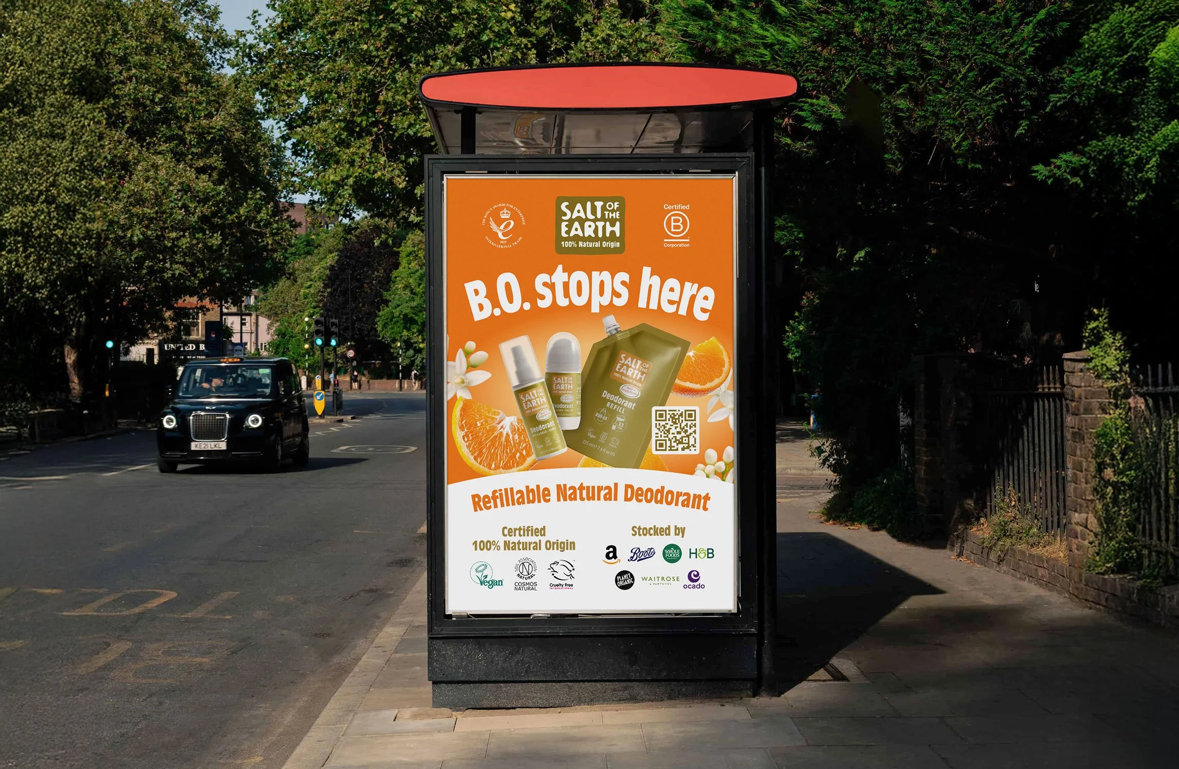 A bus stop advertisement for Salt of the Earth refillable natural deodorant, featuring orange slices, white flowers, and deodorant products, with text B.O stops here.