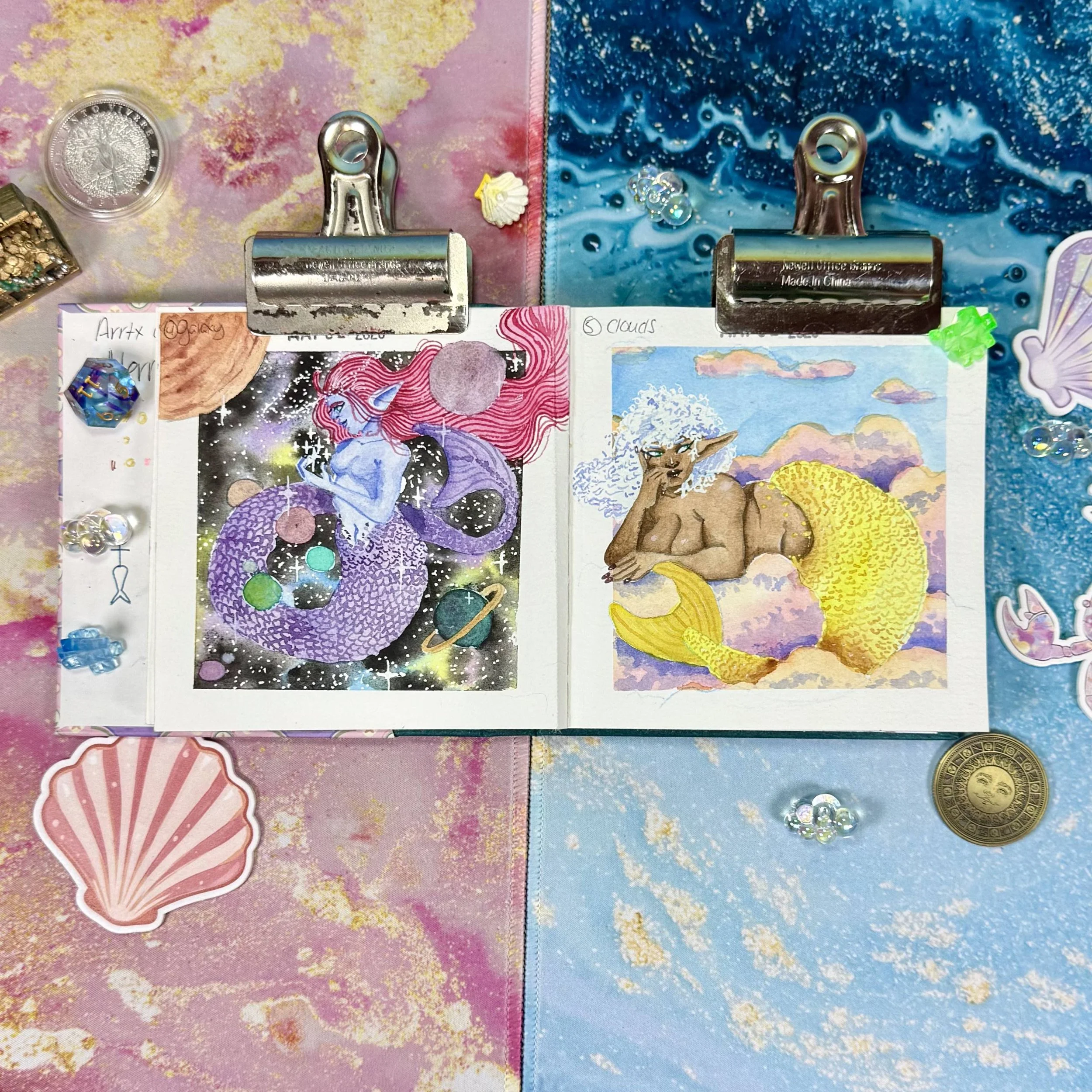 A space mermaid surrounded by stars and planets, and a Mermaid laying on top of clouds