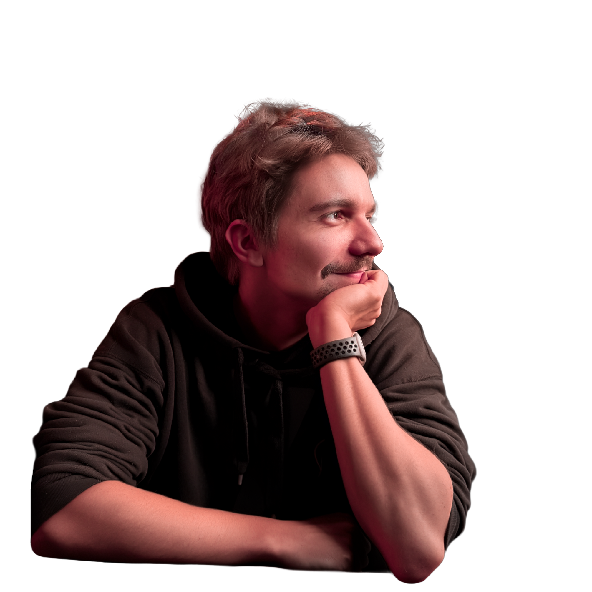A young man with brown hair and a slight beard and mustache, wearing a dark hoodie and a fitness tracker on his wrist, is resting his chin on his hand with an animated background.