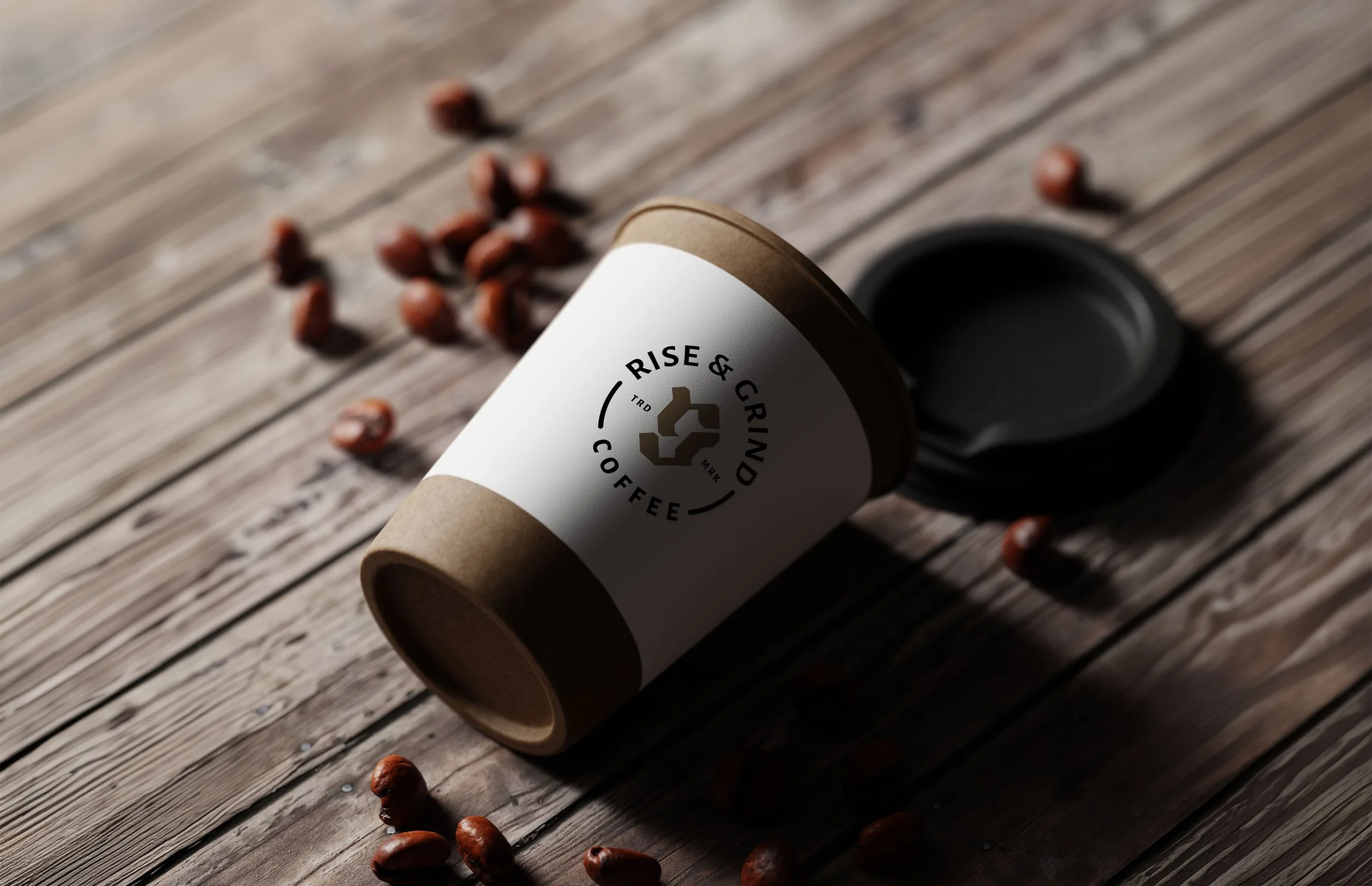 Coffee cup labeled 'Rise & Grind Coffee' with scattered coffee beans on a wooden surface.