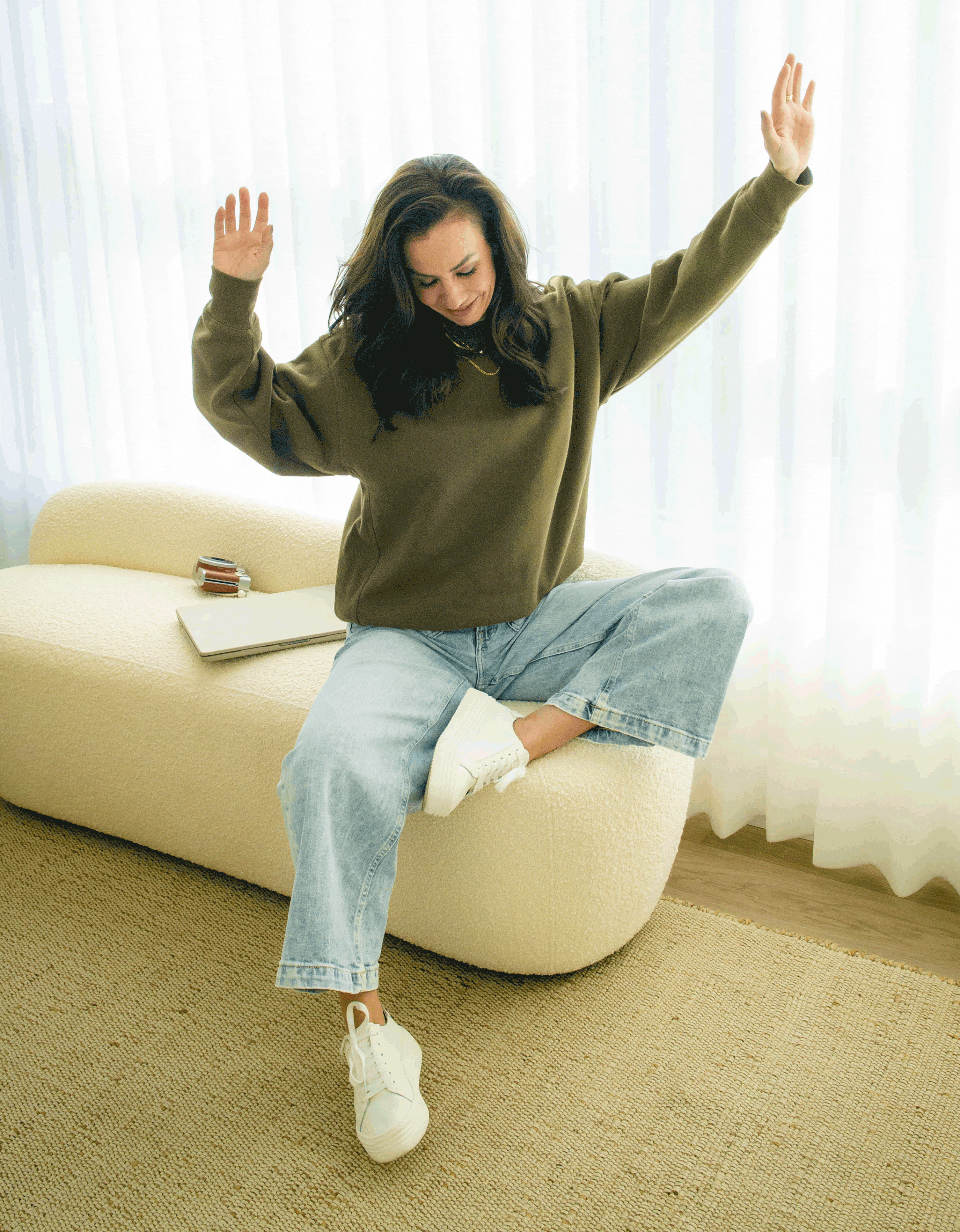 A gif of sweater designer Jodi raising her hands and smiling