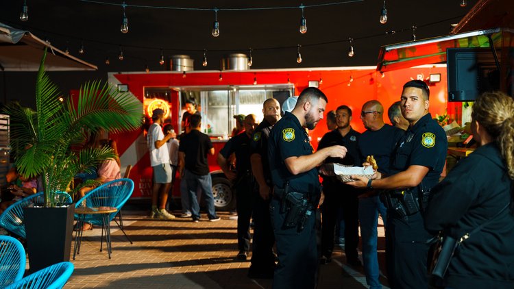 Group gathering by a food truck at La Yardita