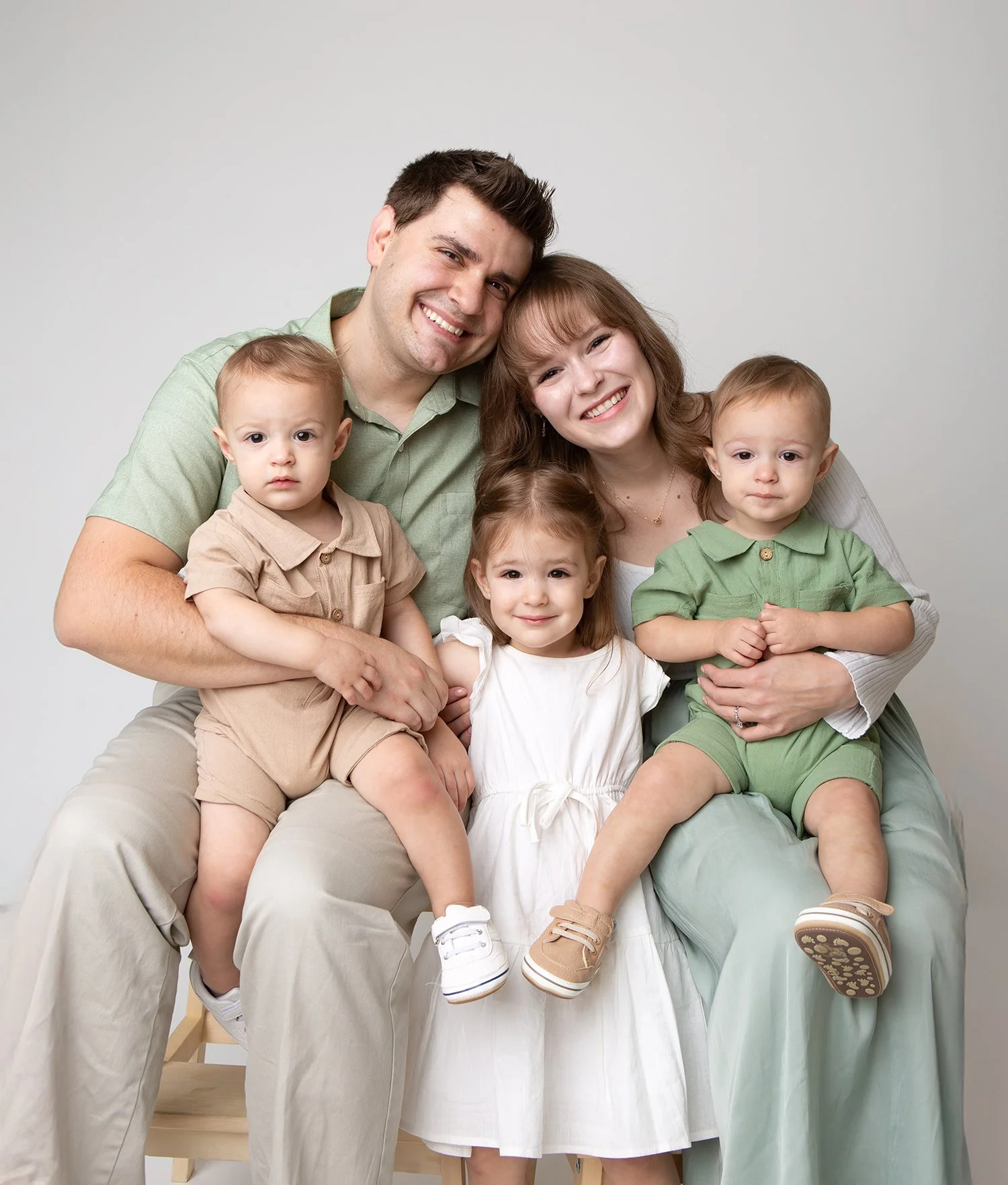 Studio family photo featuring parents with three young children, captured by a Utah County family photographer.