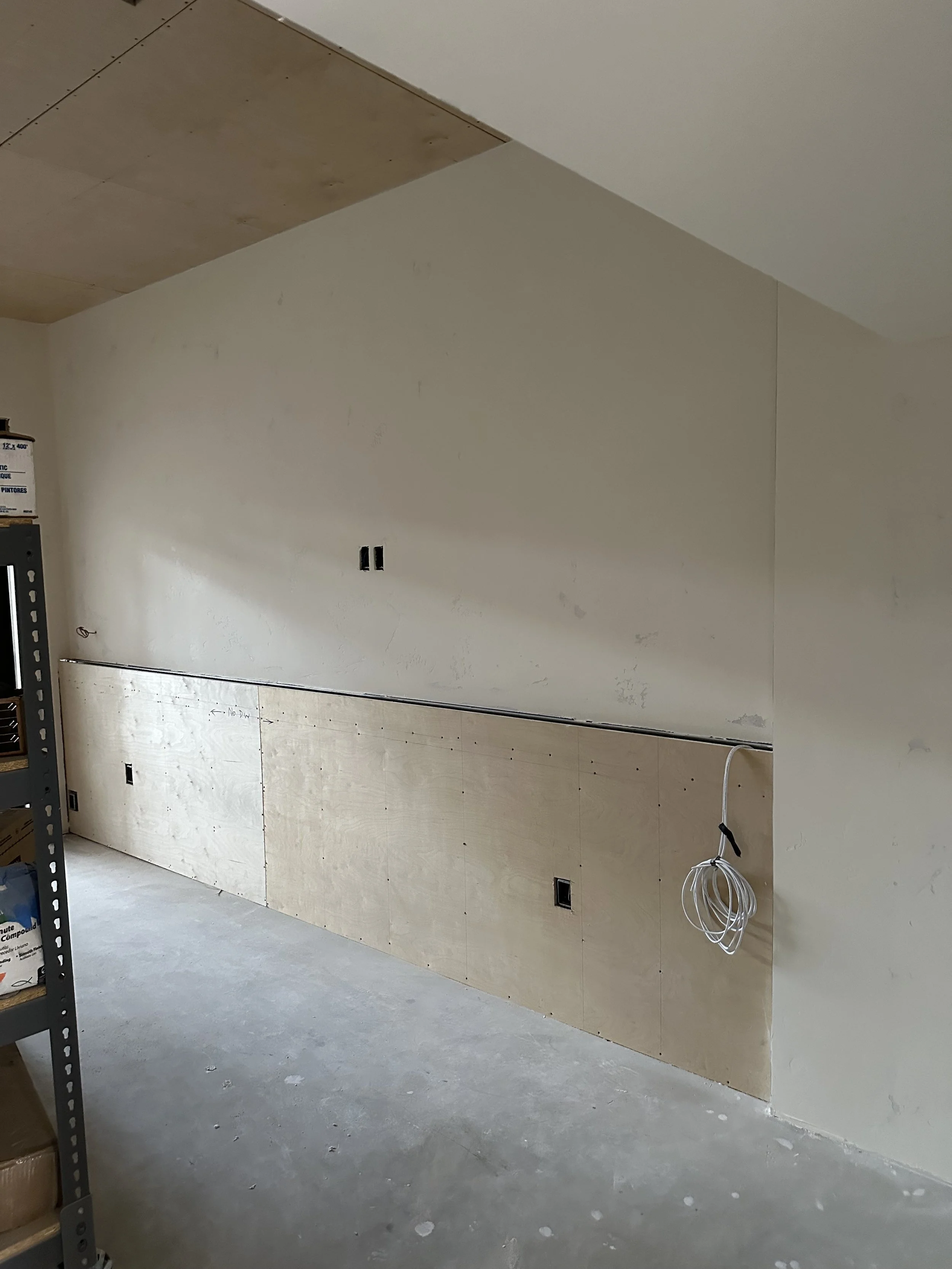  Plywood-paneled ceiling/wall section with coiled wire, mid-construction. 