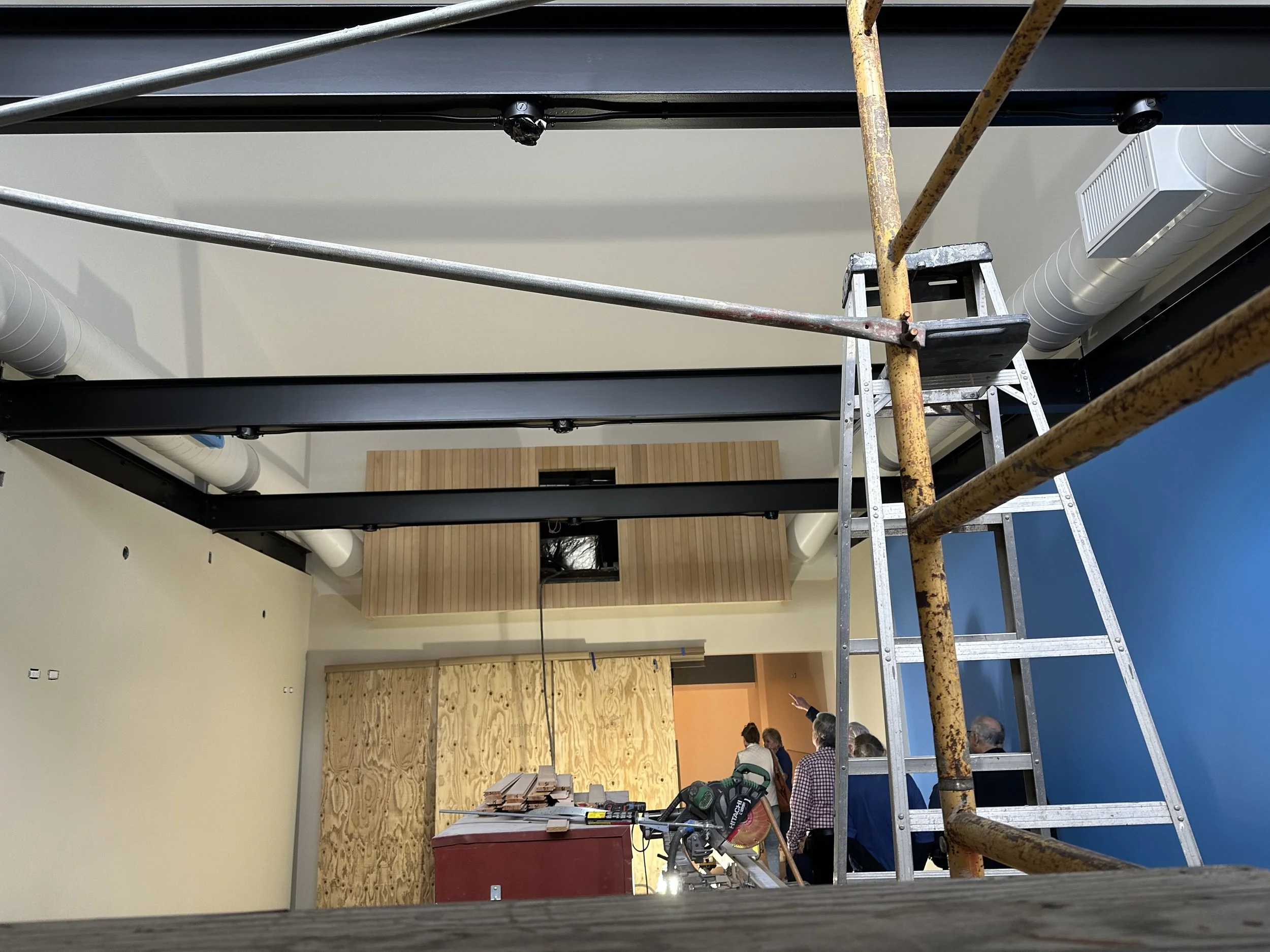  Similar wide interior shot from a different vantage point, showing the boxcar enclosure and exposed structural beams, with the same Museum Staff working below. 