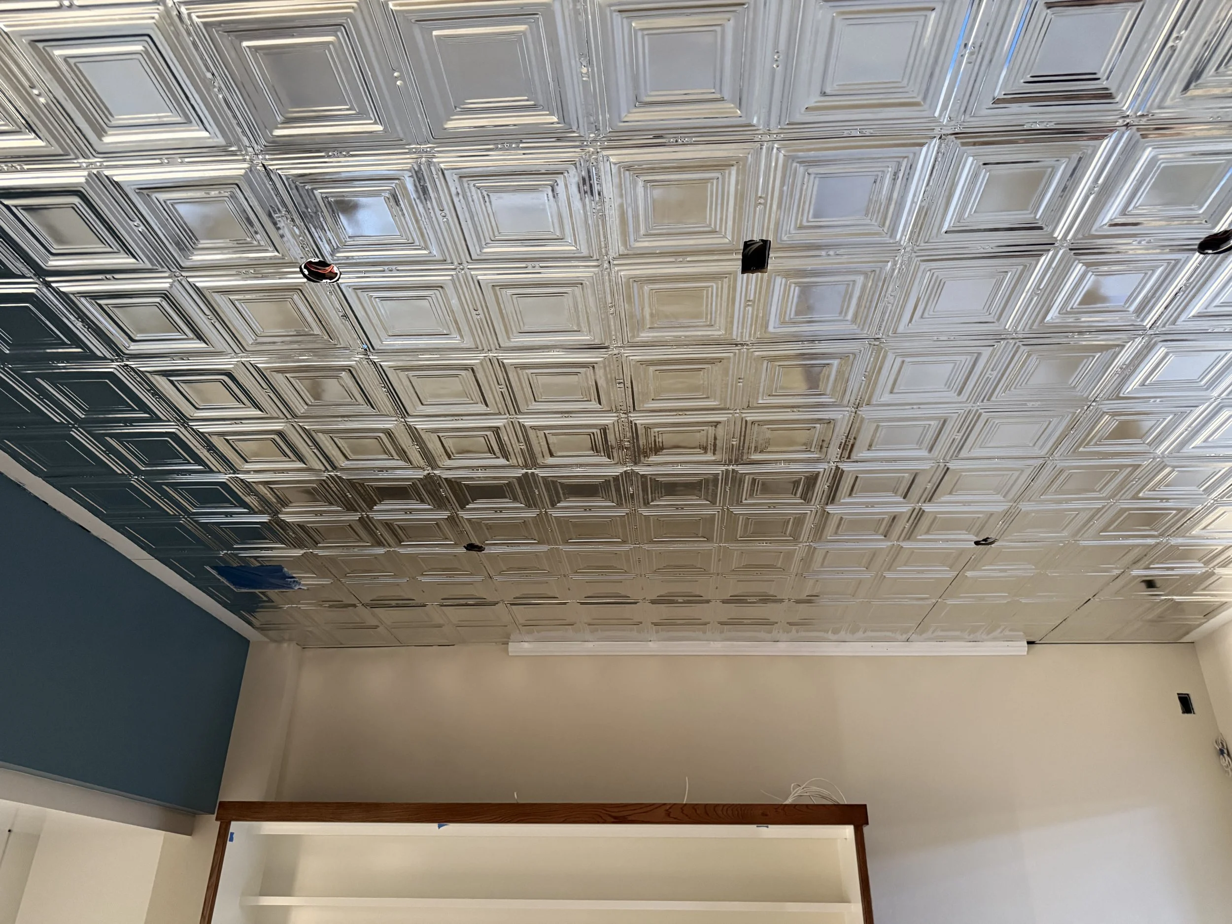  Close-up of a decorative pressed-tin ceiling — square coffered panels — installed in one of the rooms. 