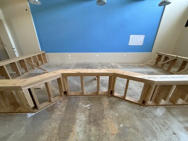  Front view of the base’s faceted outline, with the blue wall and more framing behind it. 