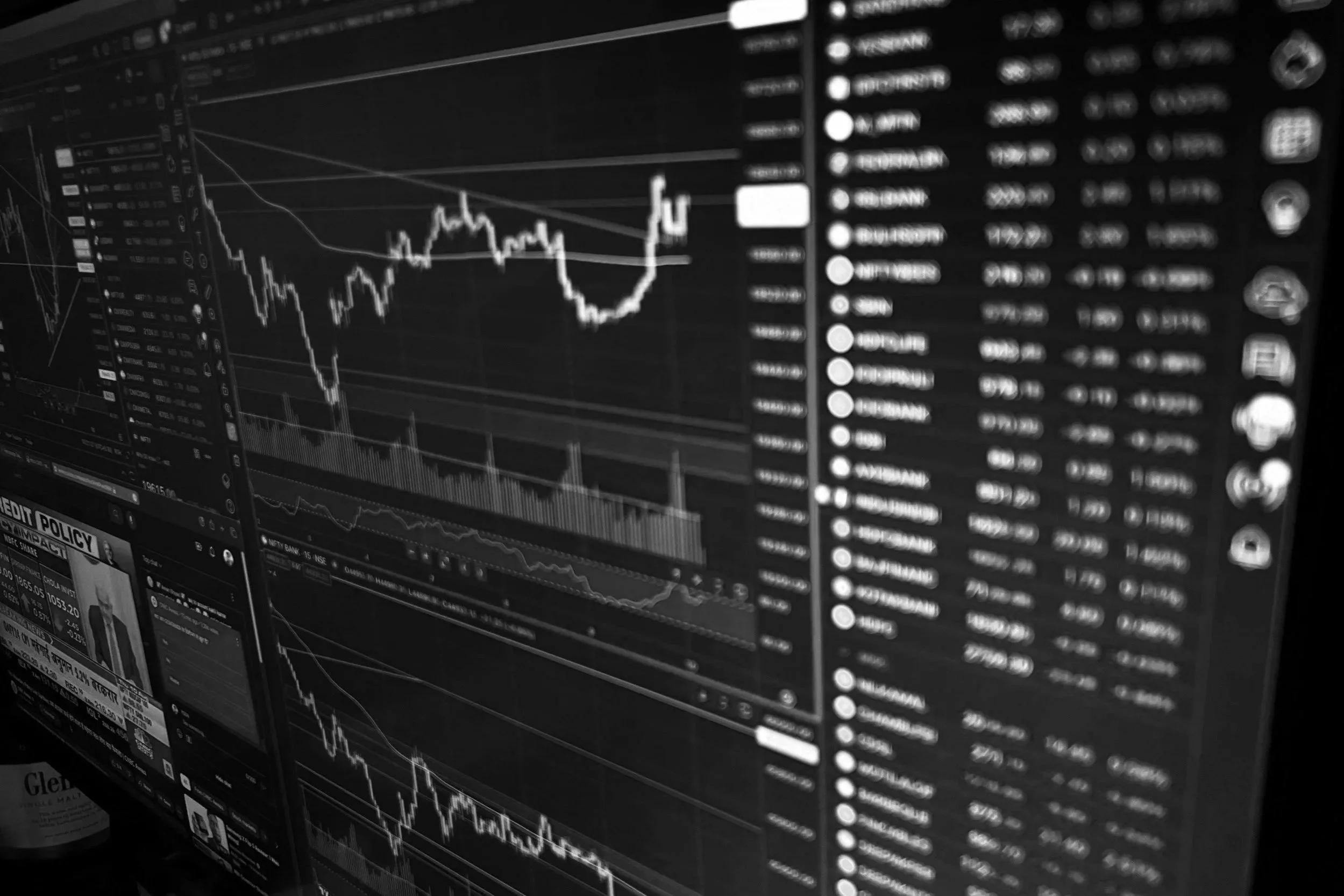 Computer screens displaying stock market charts, graphs, and data.