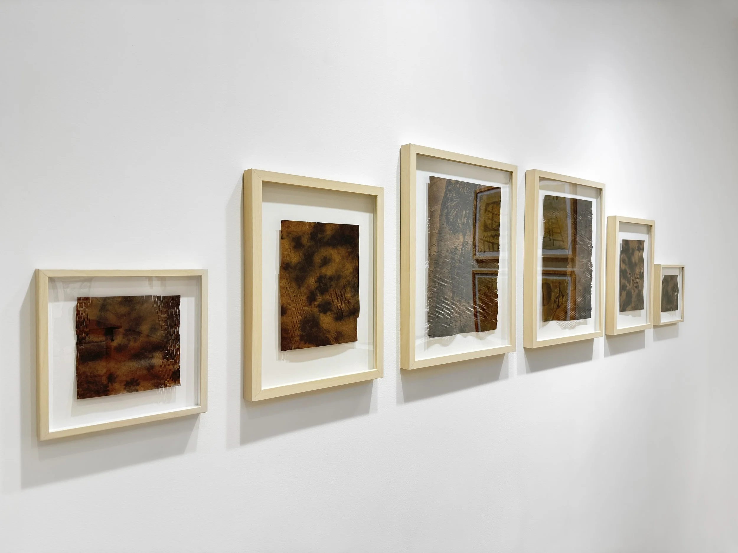 Installation view of Held Gently paper lattice work; open grid, subtle shadows across the wall.