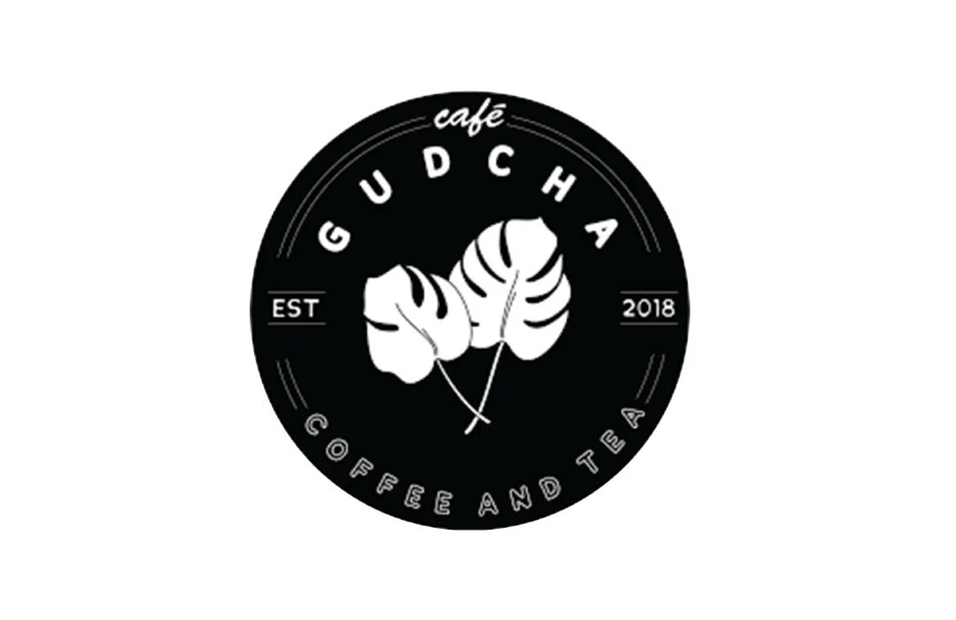 Logo for GUDCHA Cafe with stylized leaves in the center, surrounded by text reading "GUDCHA Cafe," "Coffee and Tea," and the establishment year 2018.