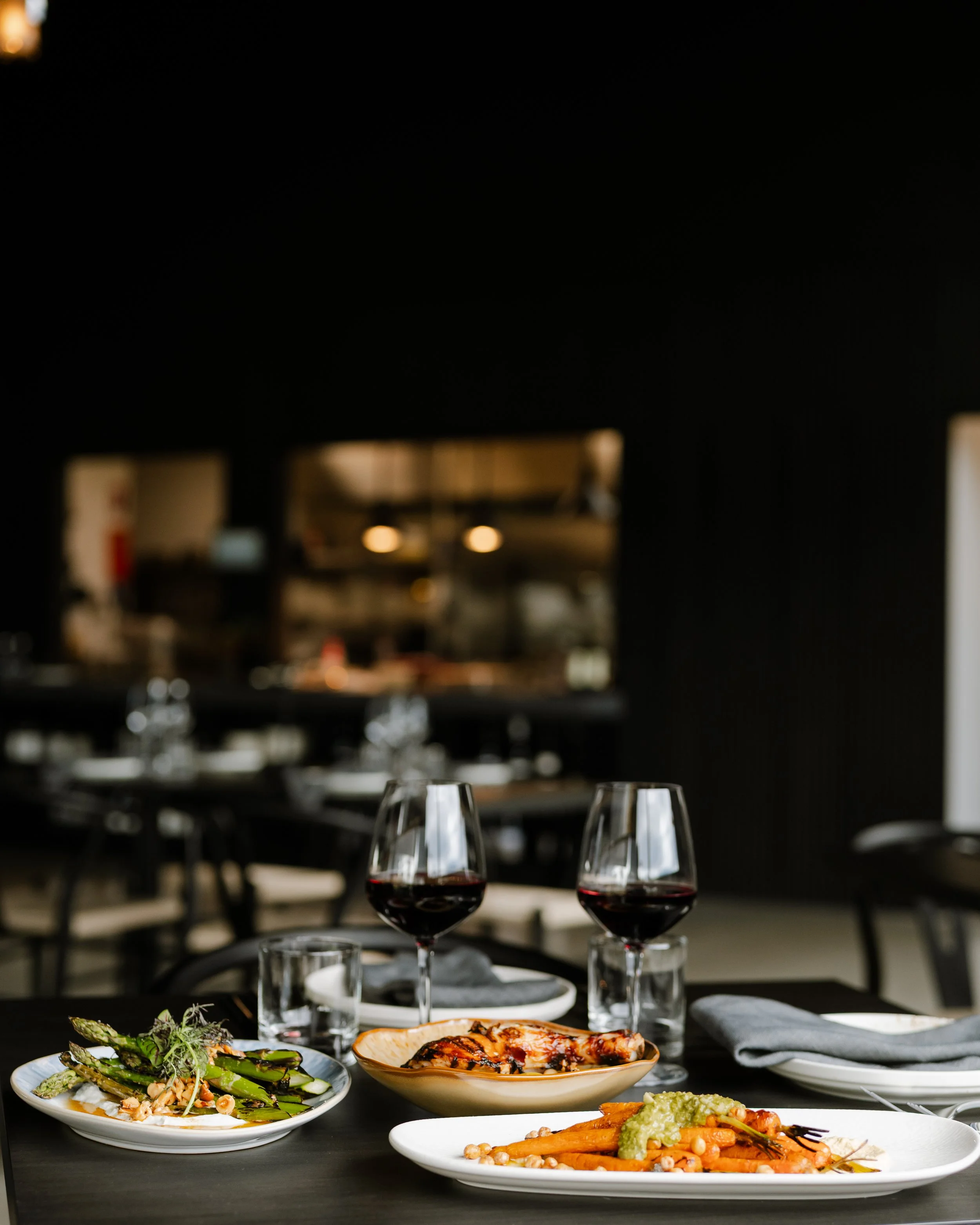 Table set with wine and shared plates at WADE restaurant, Wineglass Bay Estate, Freycinet