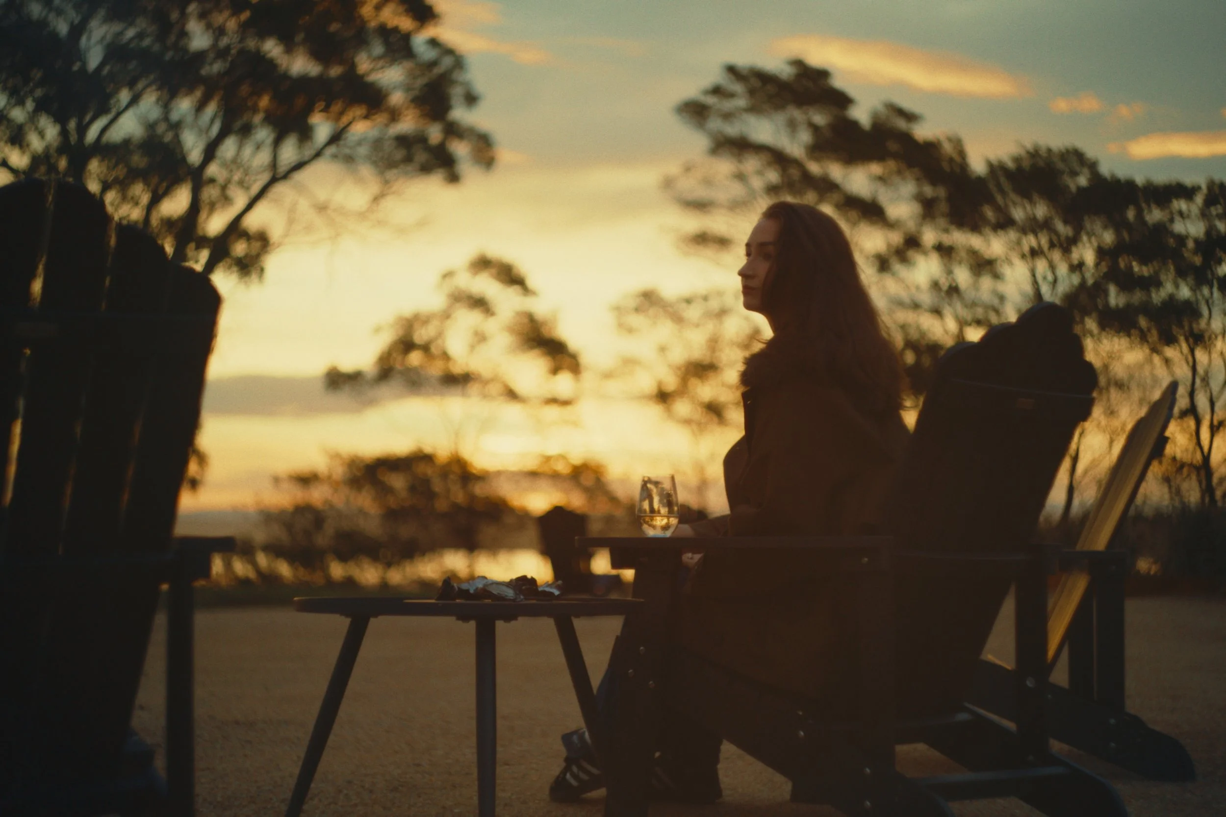 Guest with white wine at sunset at the Wineglass Bay Estate cellar door
