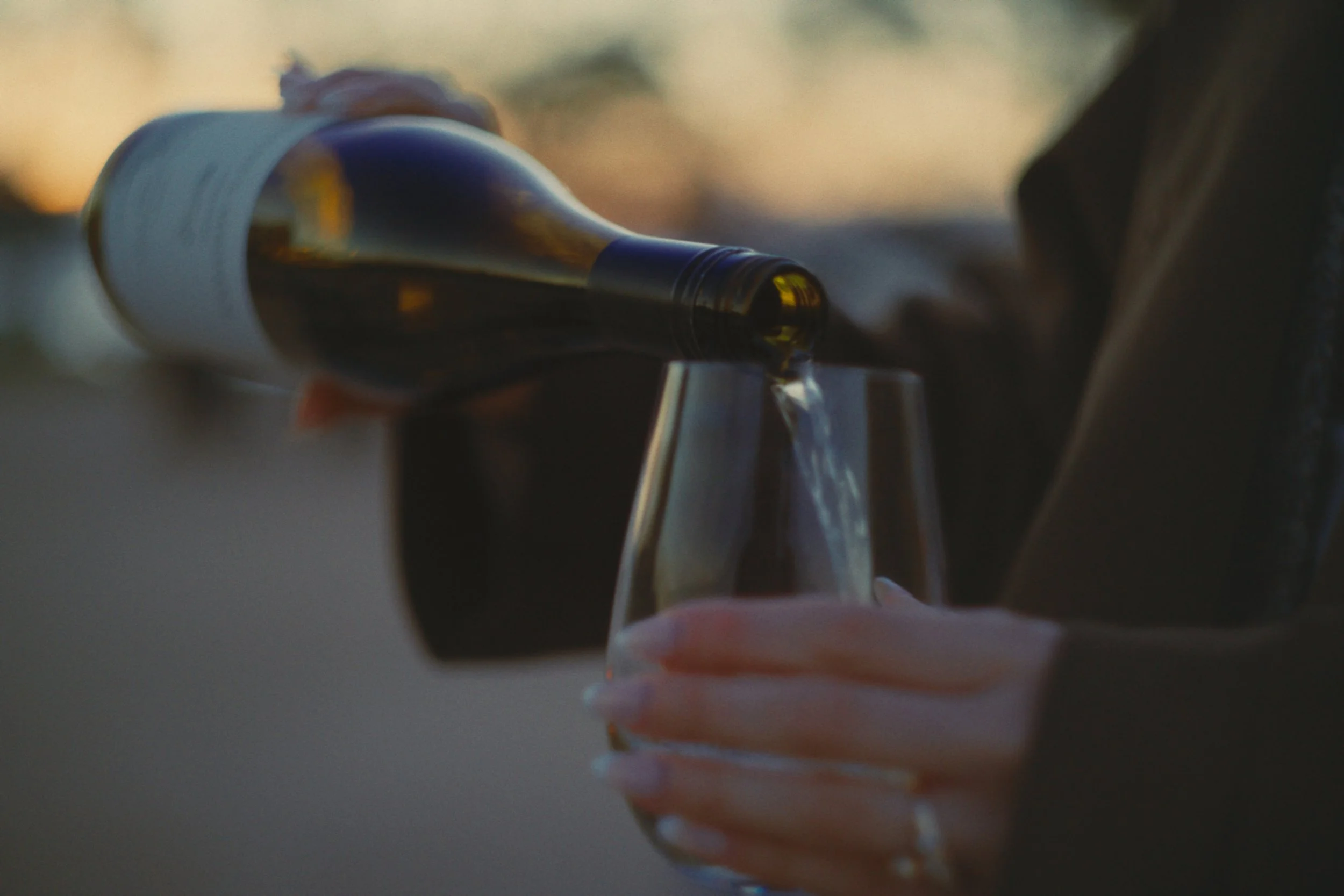Pouring white wine at dusk at the Wineglass Bay Estate cellar door, Freycinet