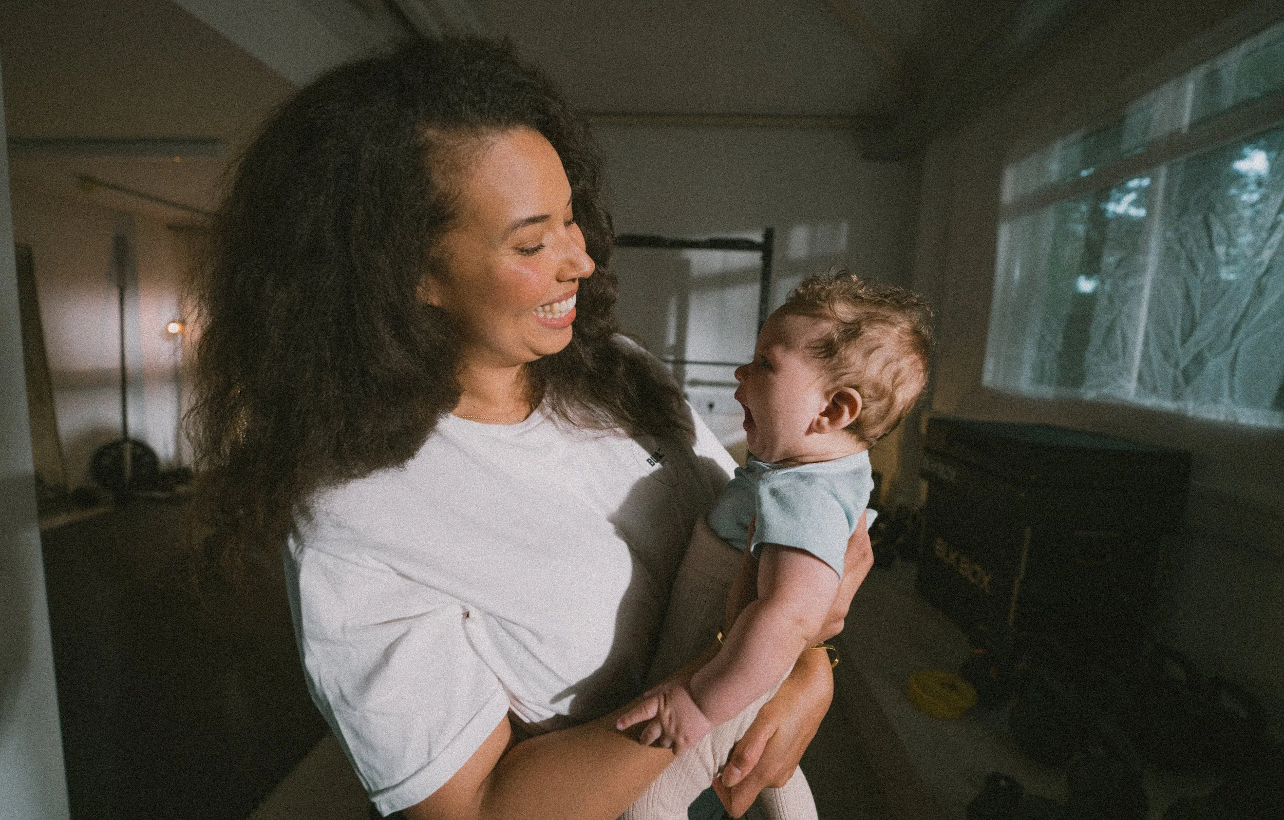 Mother bonding with her baby after a supportive postnatal strength class designed for women rebuilding fitness safely.