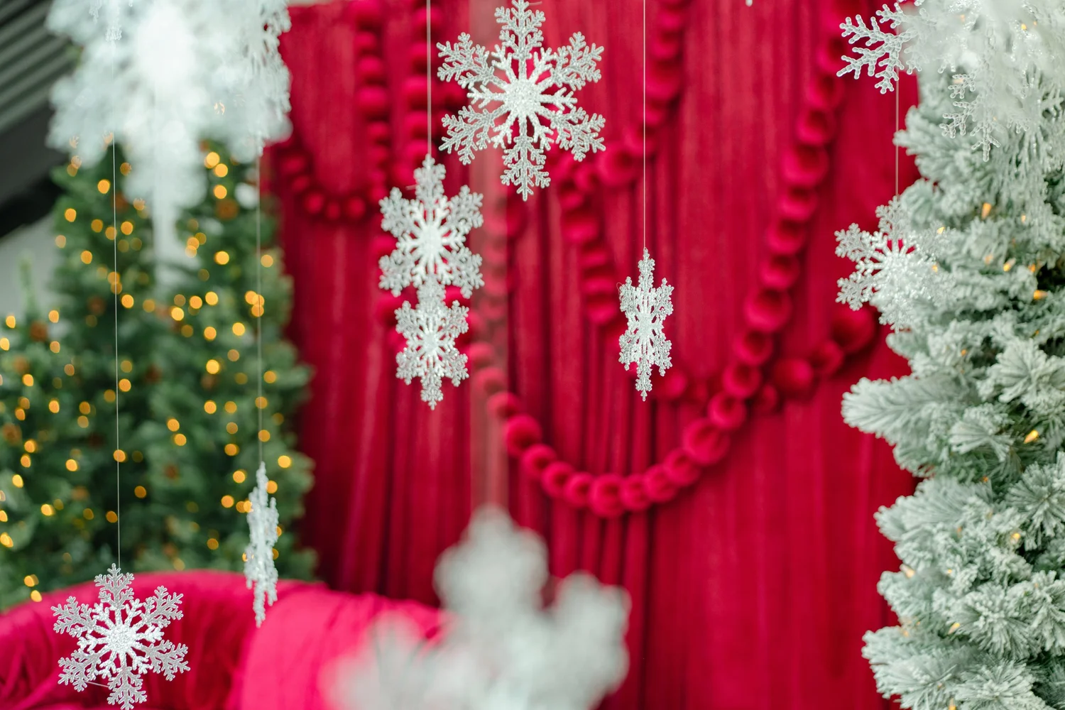 Snowflakes from the Winter White set framed in front of the cranberry velvet drape, showing how the two holiday sets cross over at an Austin photo studio