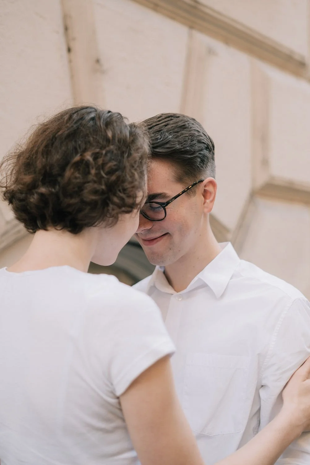 Casal sorridente dançando junto, com o rosto perto um do outro, em ambiente interno com teto de madeira.