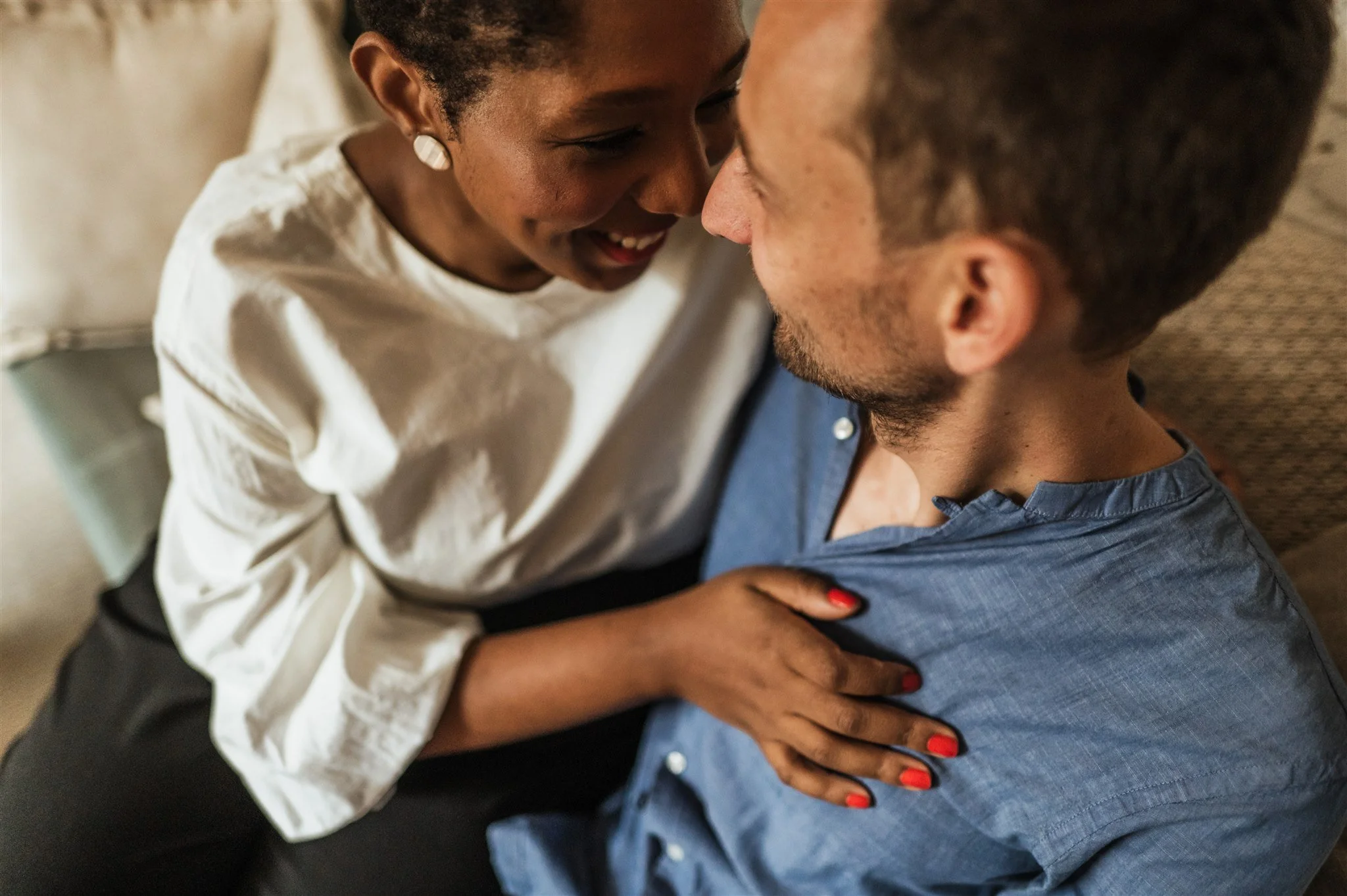 Couple embracing closely, woman in white top, man in blue shirt