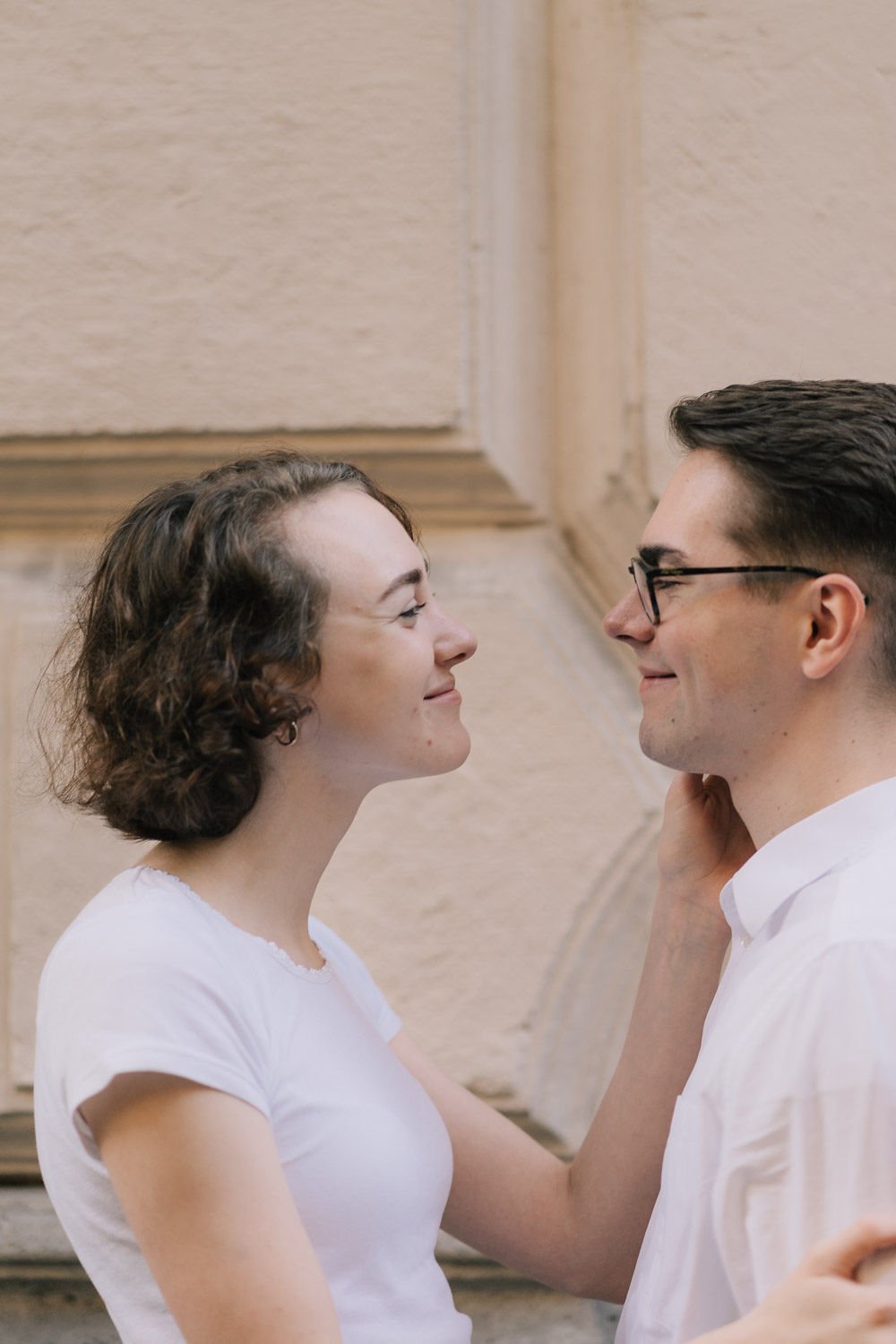 Casal sorridente olhando um para o outro em um ambiente interno.