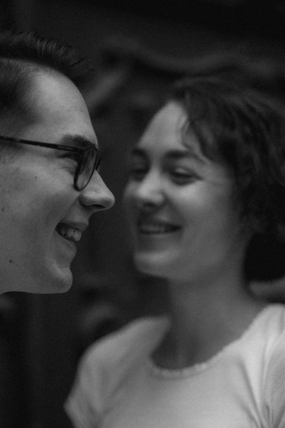 Duas pessoas sorrindo lado a lado, rosto próximo, com expressão de alegria.