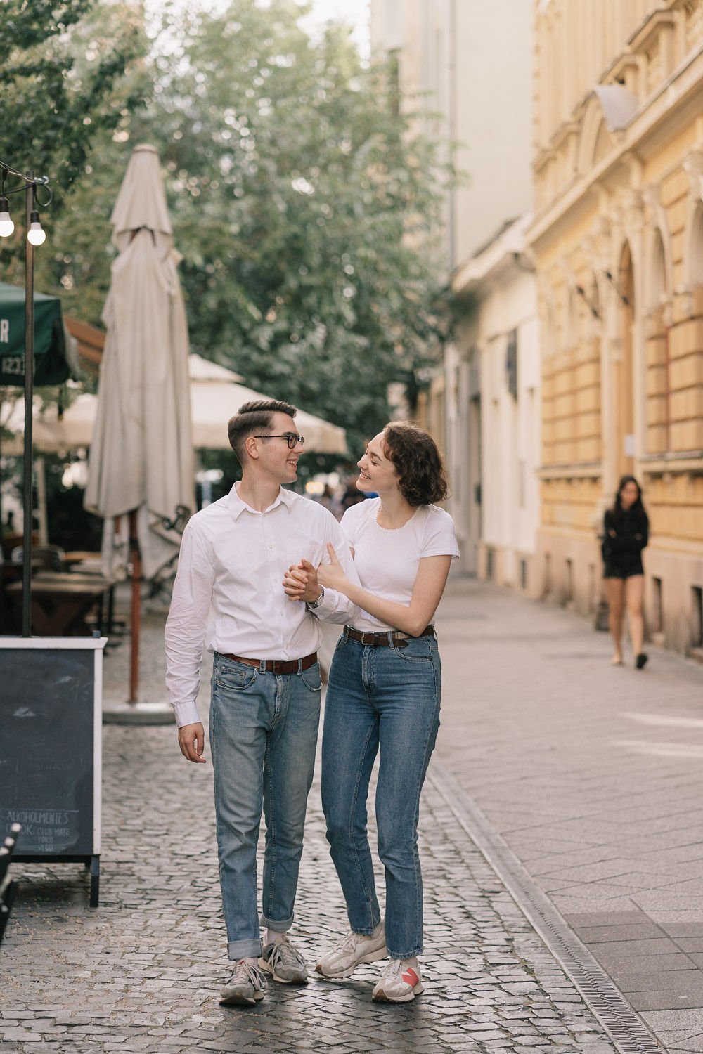 Um homem e uma mulher felizes caminhando juntos na rua, sorrindo um para o outro.