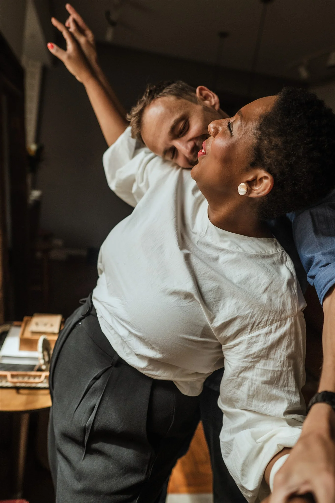 A joyful couple dancing closely in a warmly lit room.