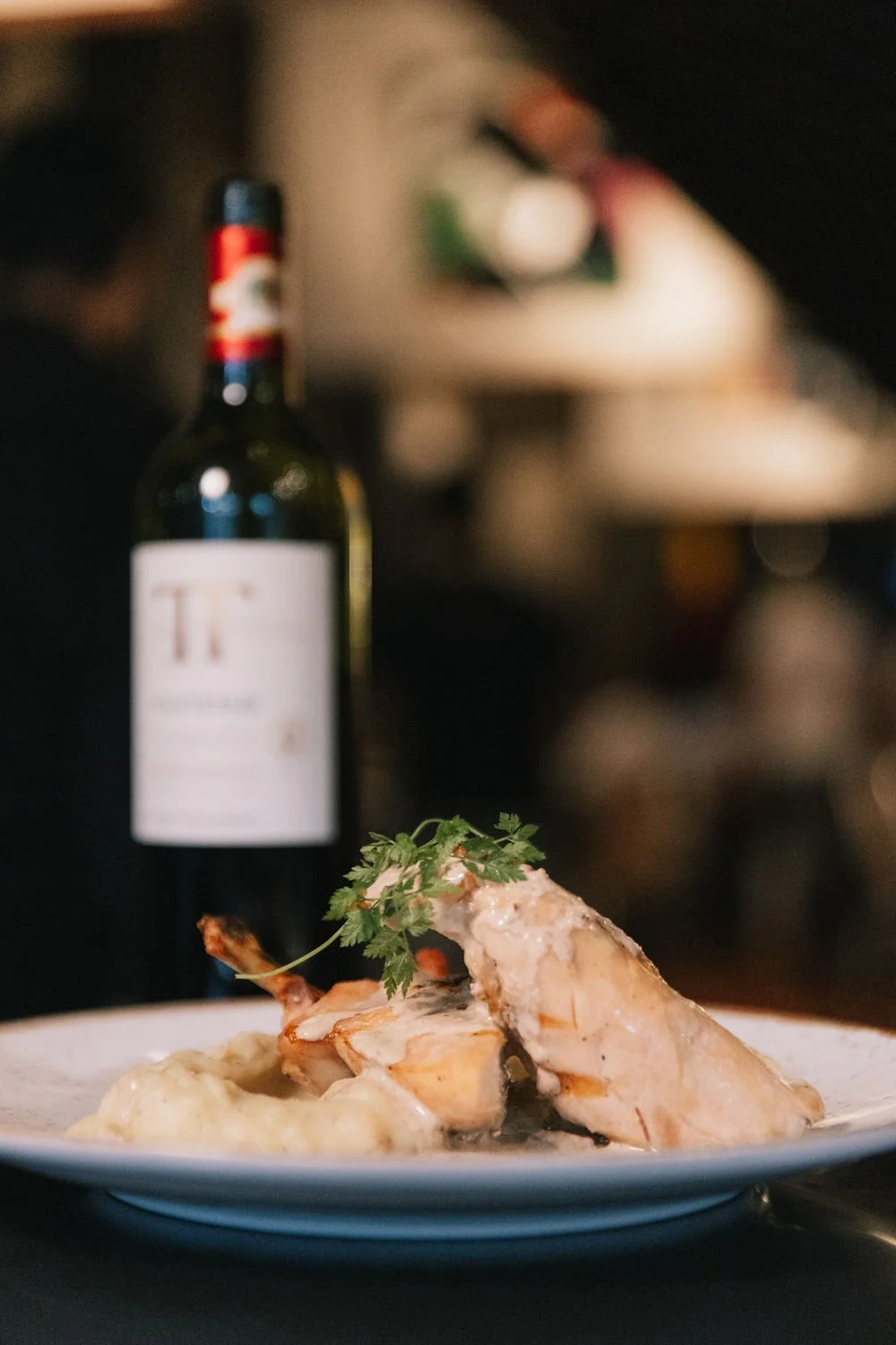 Prato com pedaços de carne com molho e ervas, acompanhado de purê de batatas ou acompanhamento cremoso.