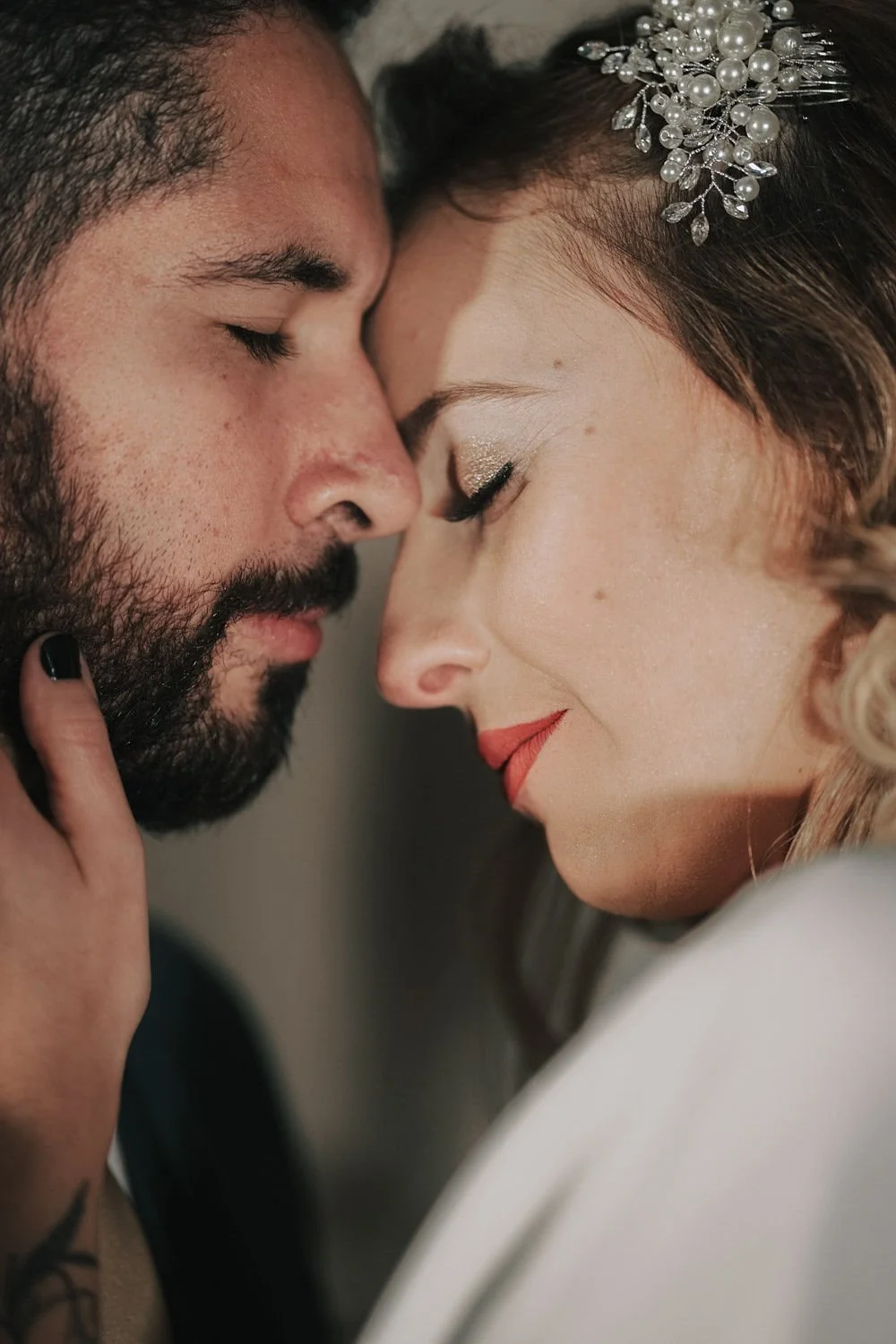 Casal apaixonado com testa e olhos fechados, tocando testa com testa, em clima romântico.