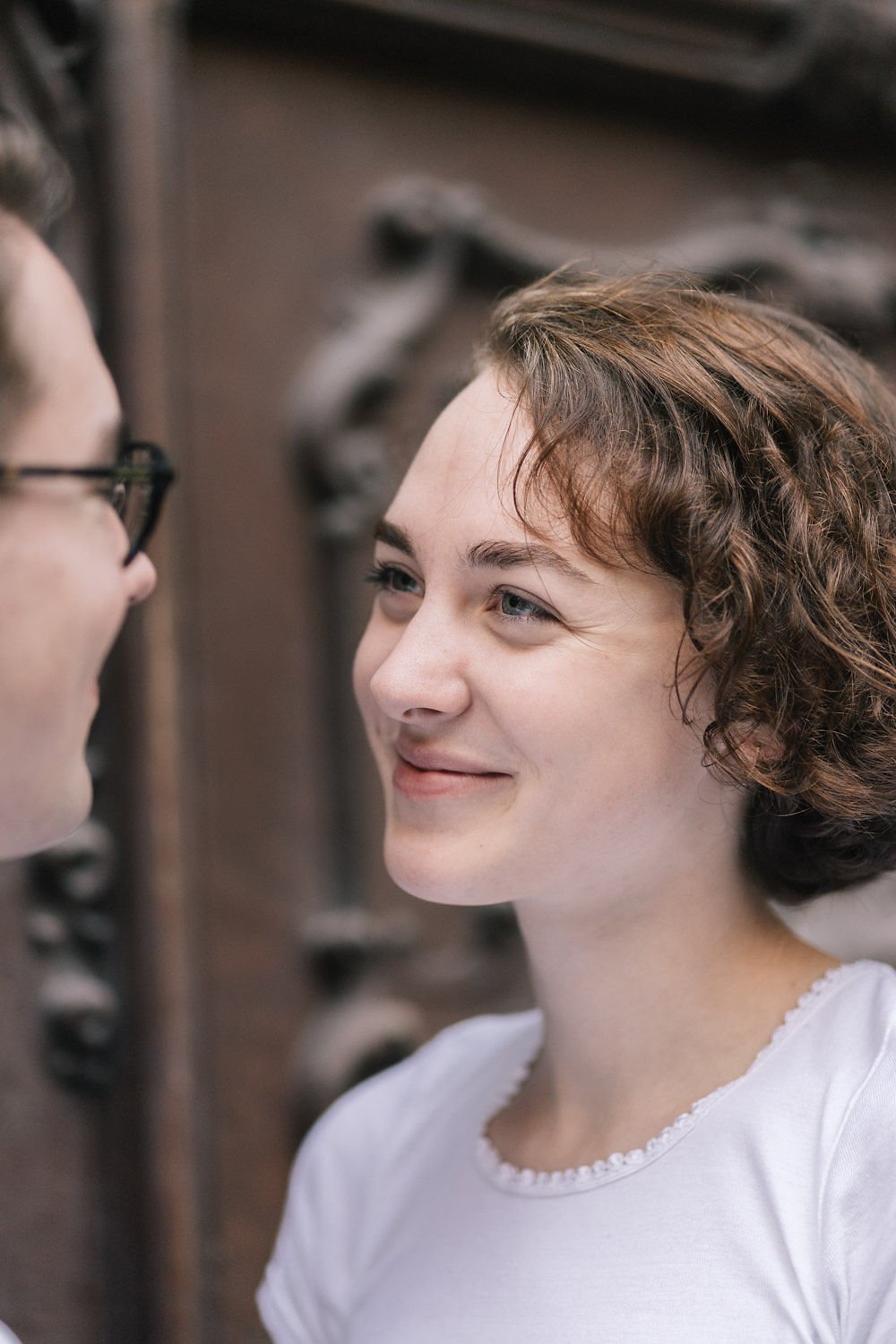 Duas mulheres sorrindo uma para a outra em um ambiente interno.