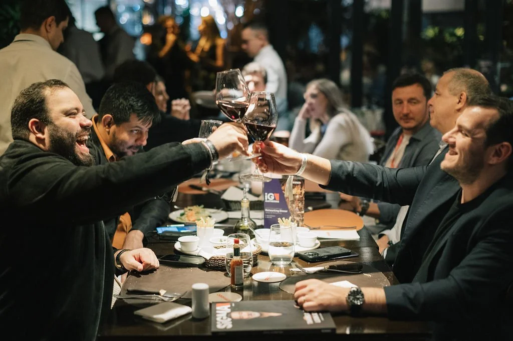 Homens brindando com taças de vinho em uma confraternização em restaurante ou jantar.